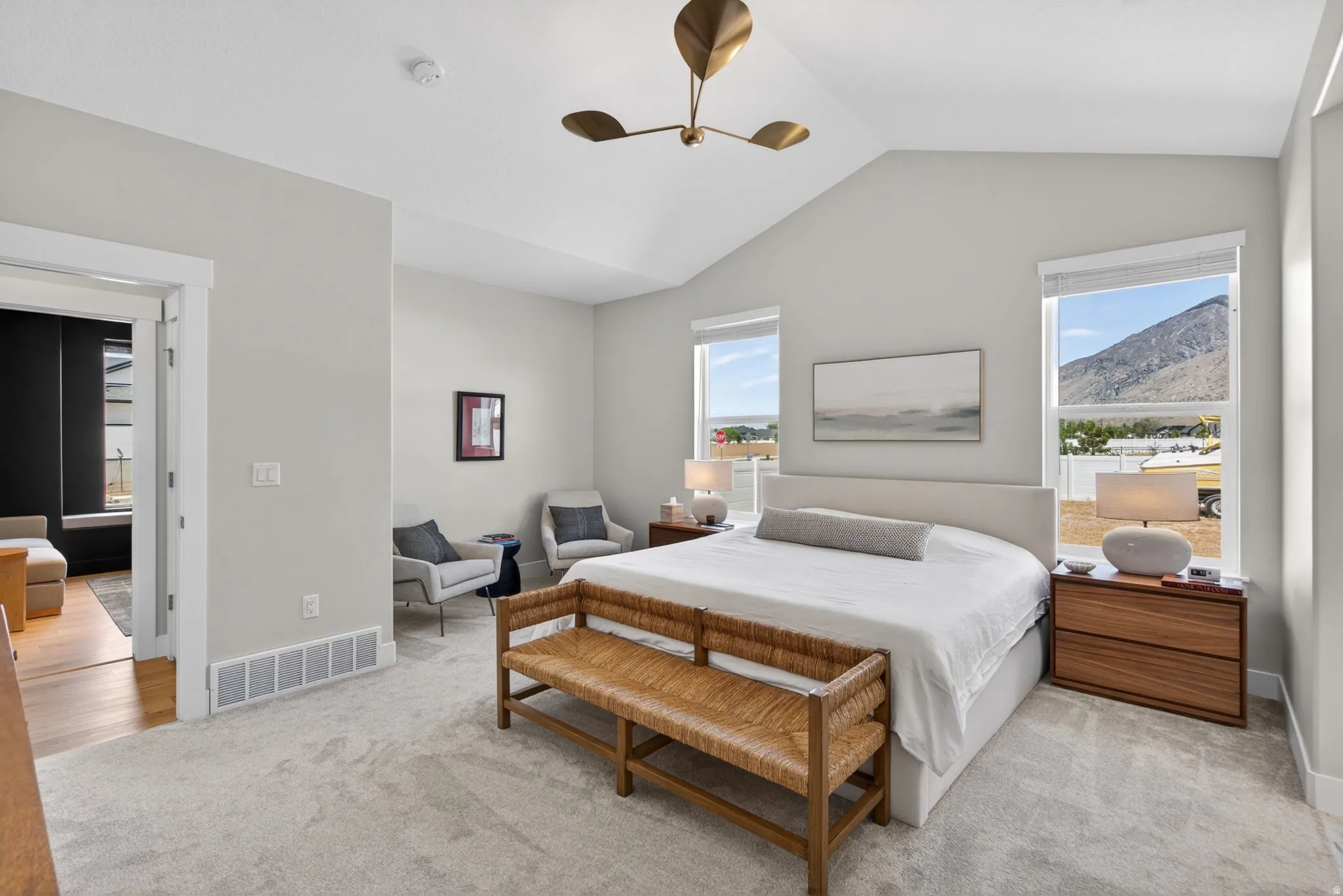 Bedroom with light carpet, a ceiling fan, and multiple windows