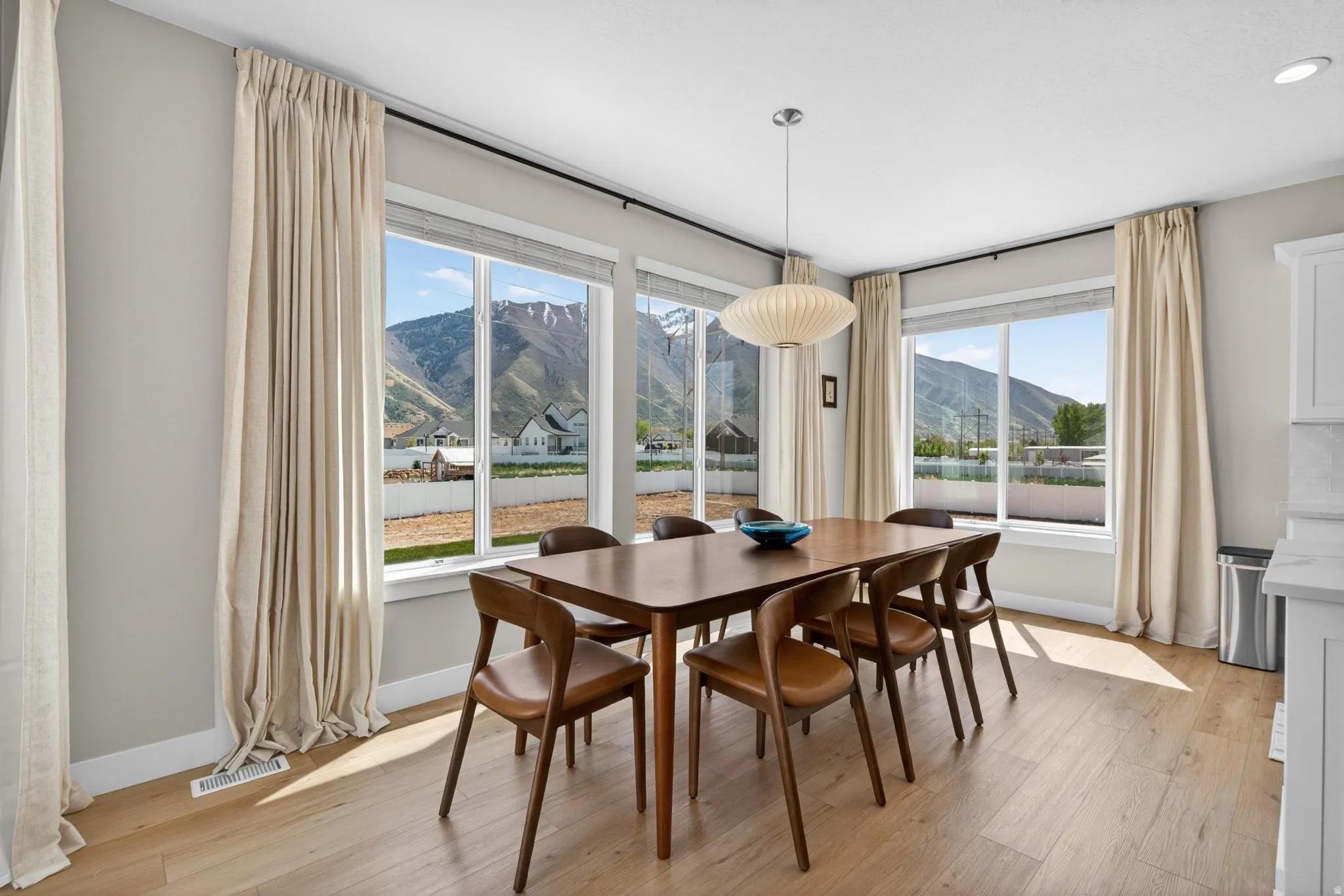 Dining space with a mountain view and light wood-style floors