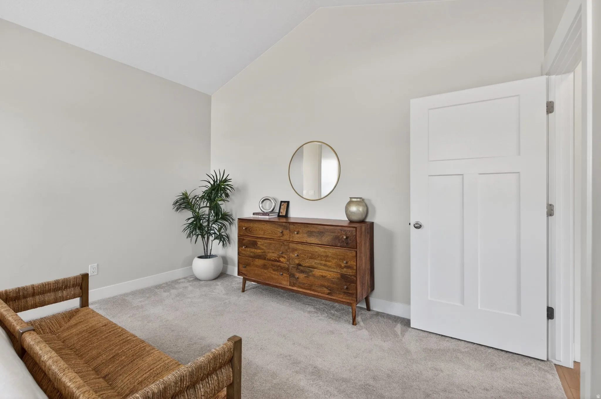 Living area featuring vaulted ceiling and light colored carpet