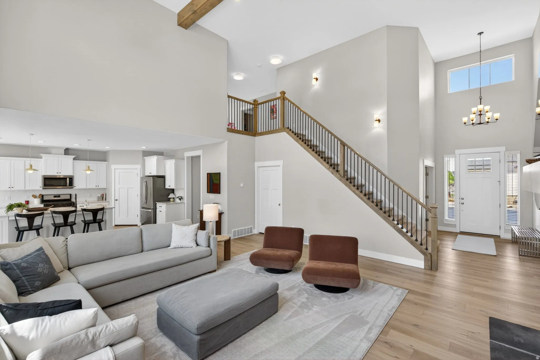 Living room with suspended lighting and light wood finished floors