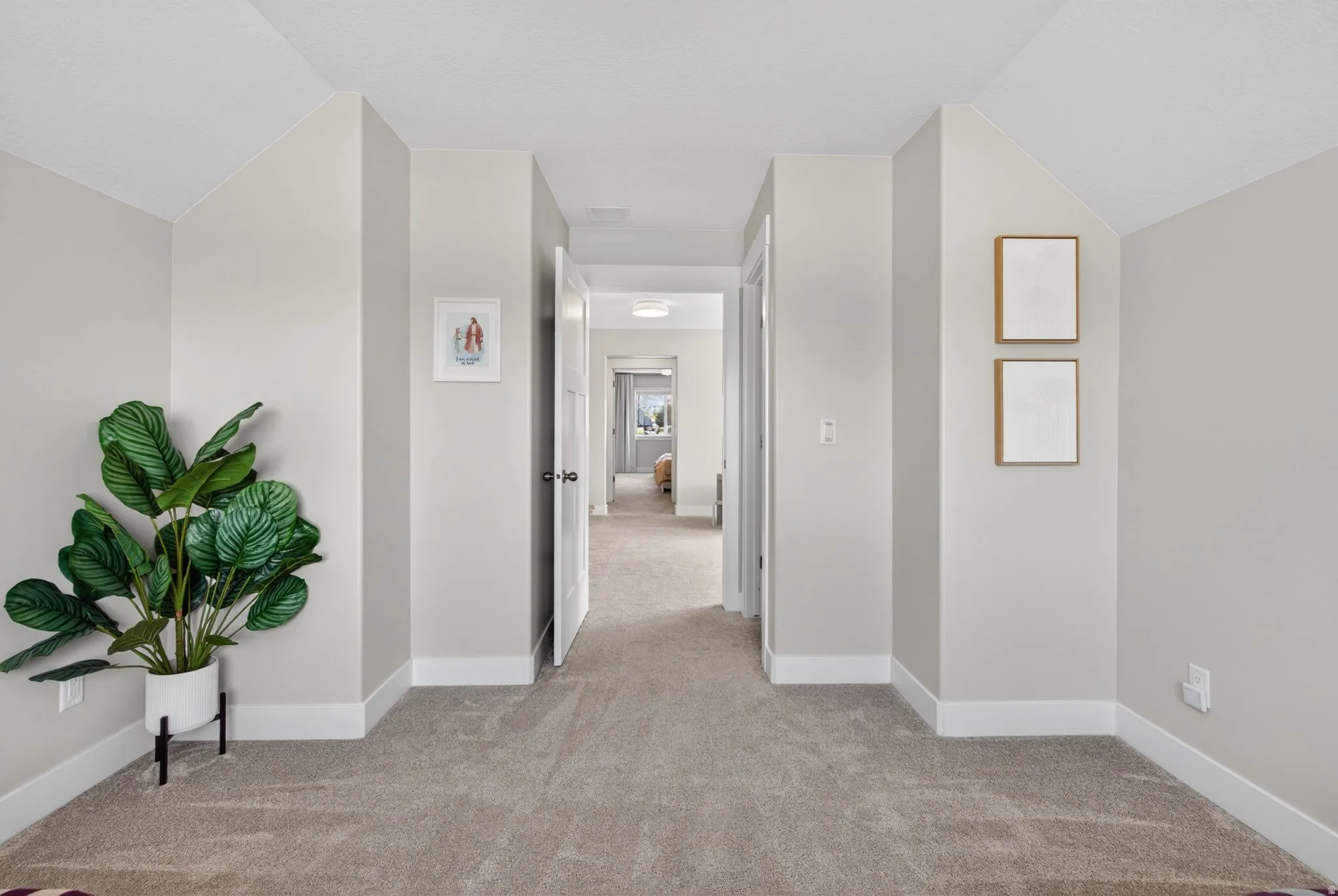 Corridor with lofted ceiling and light carpet