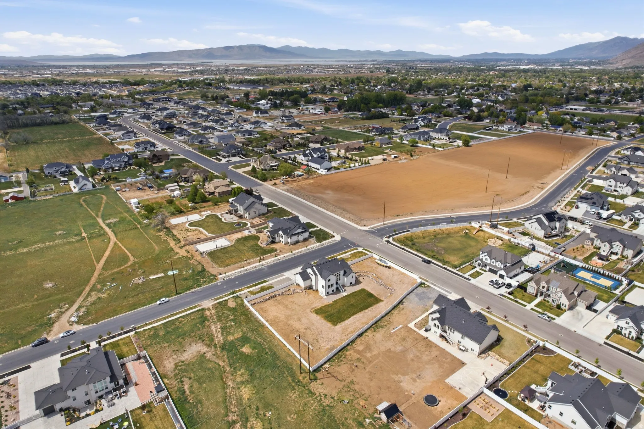 Aerial view of property and surrounding area with nearby suburban area and a mountainous background