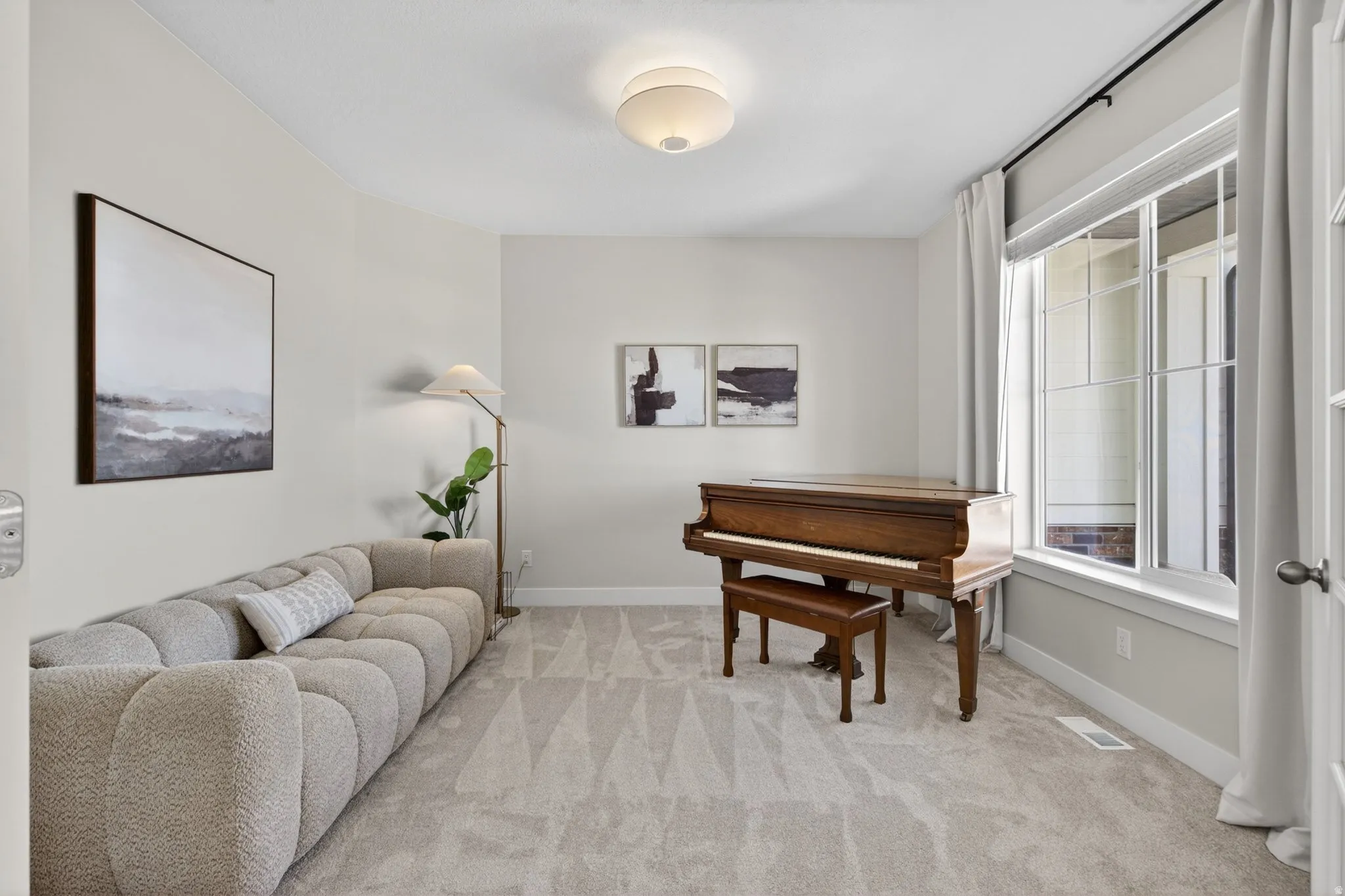 Living area featuring light carpet and baseboards