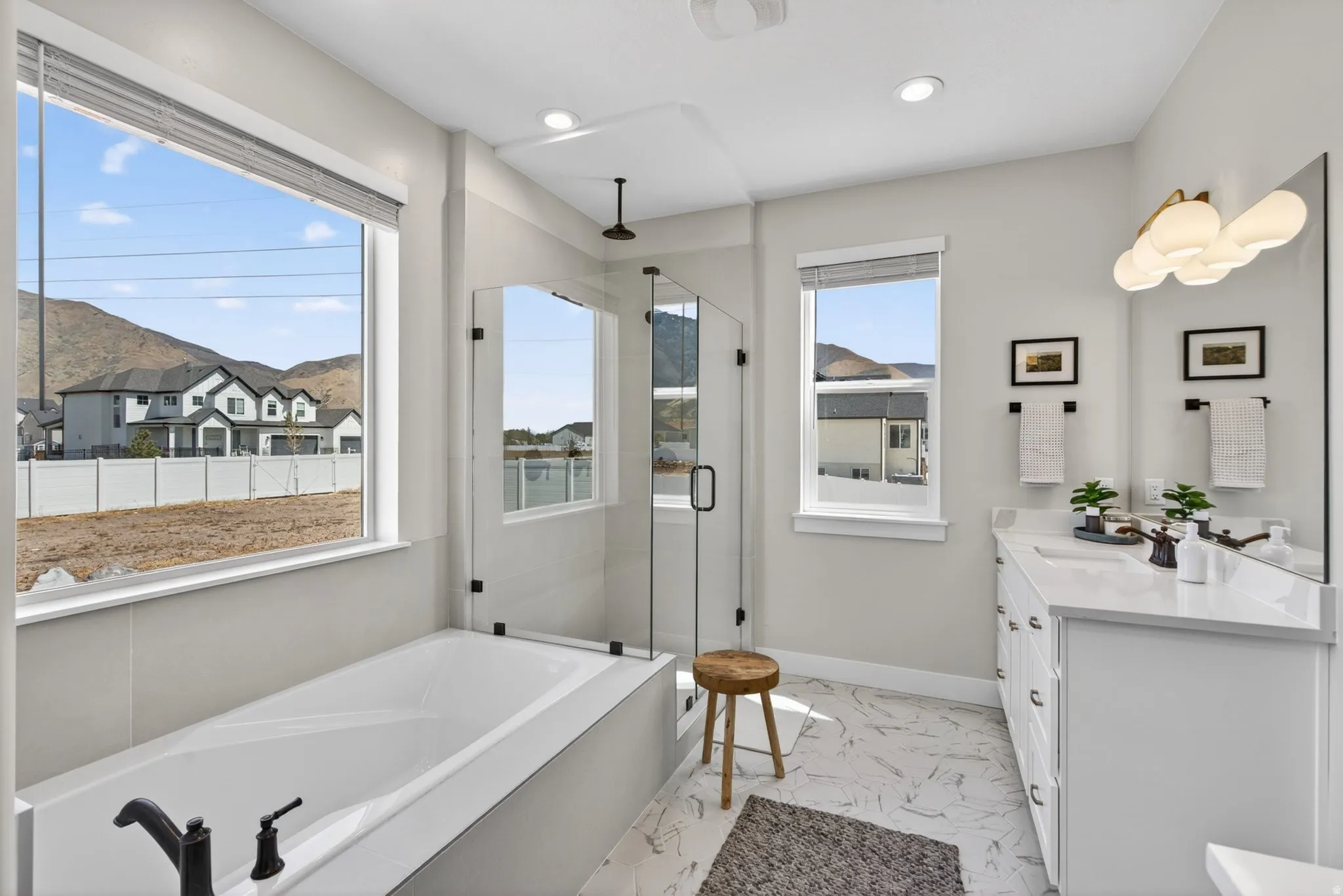 Bathroom with vanity, a stall shower, a garden tub, and light marble finish floors