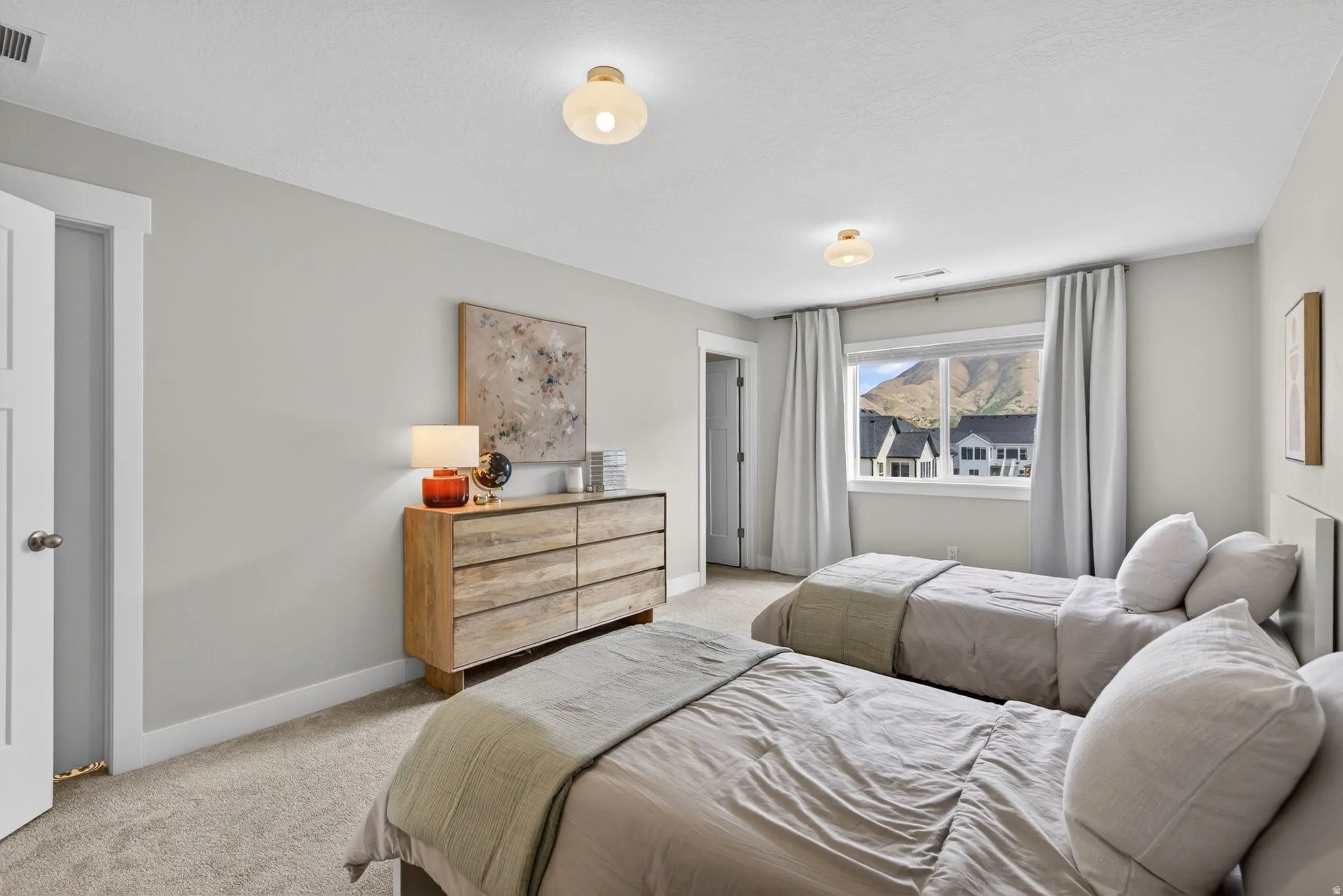 Bedroom with light colored carpet and baseboards