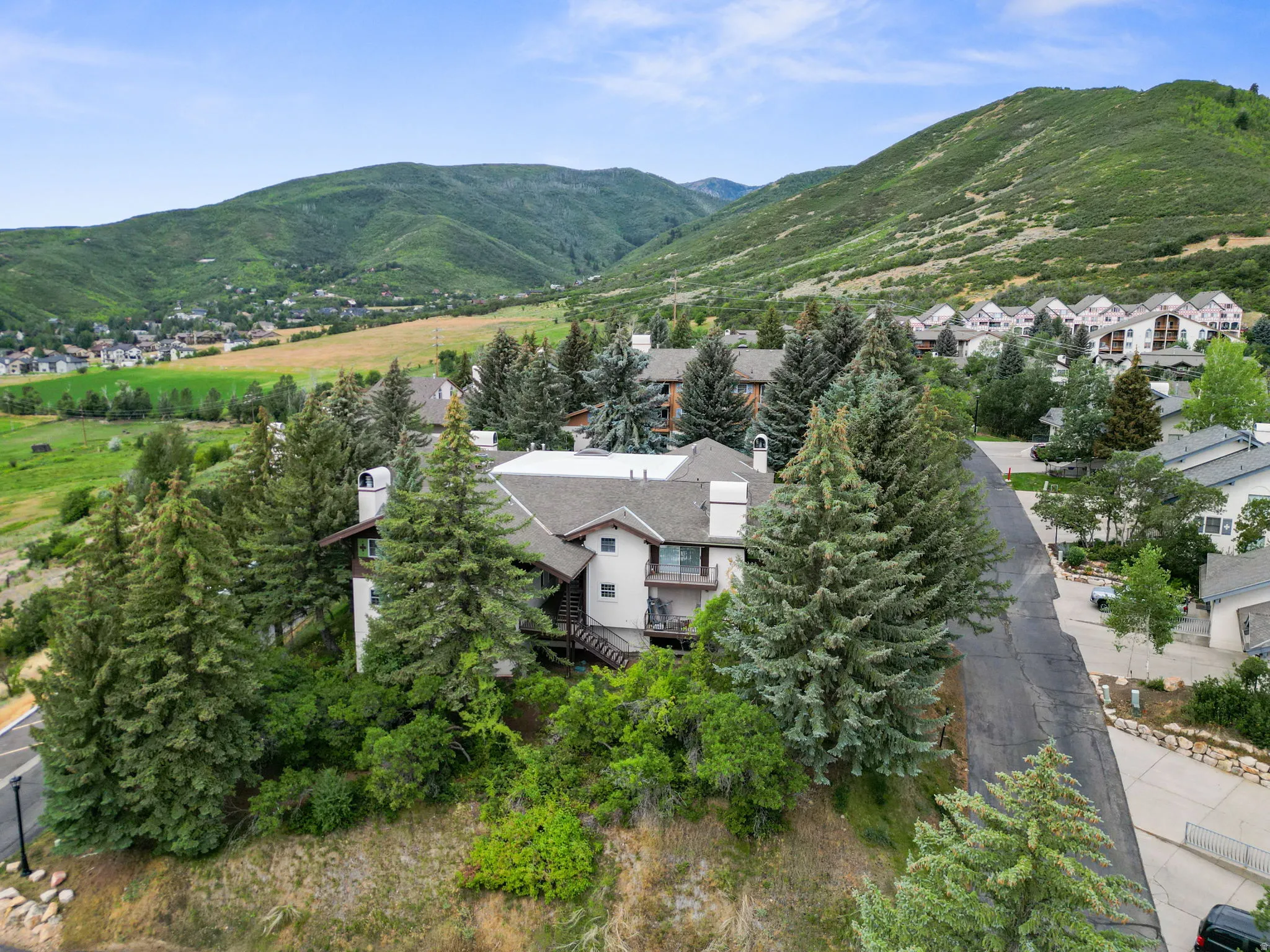 Aerial view of property and surrounding area featuring a mountain backdrop