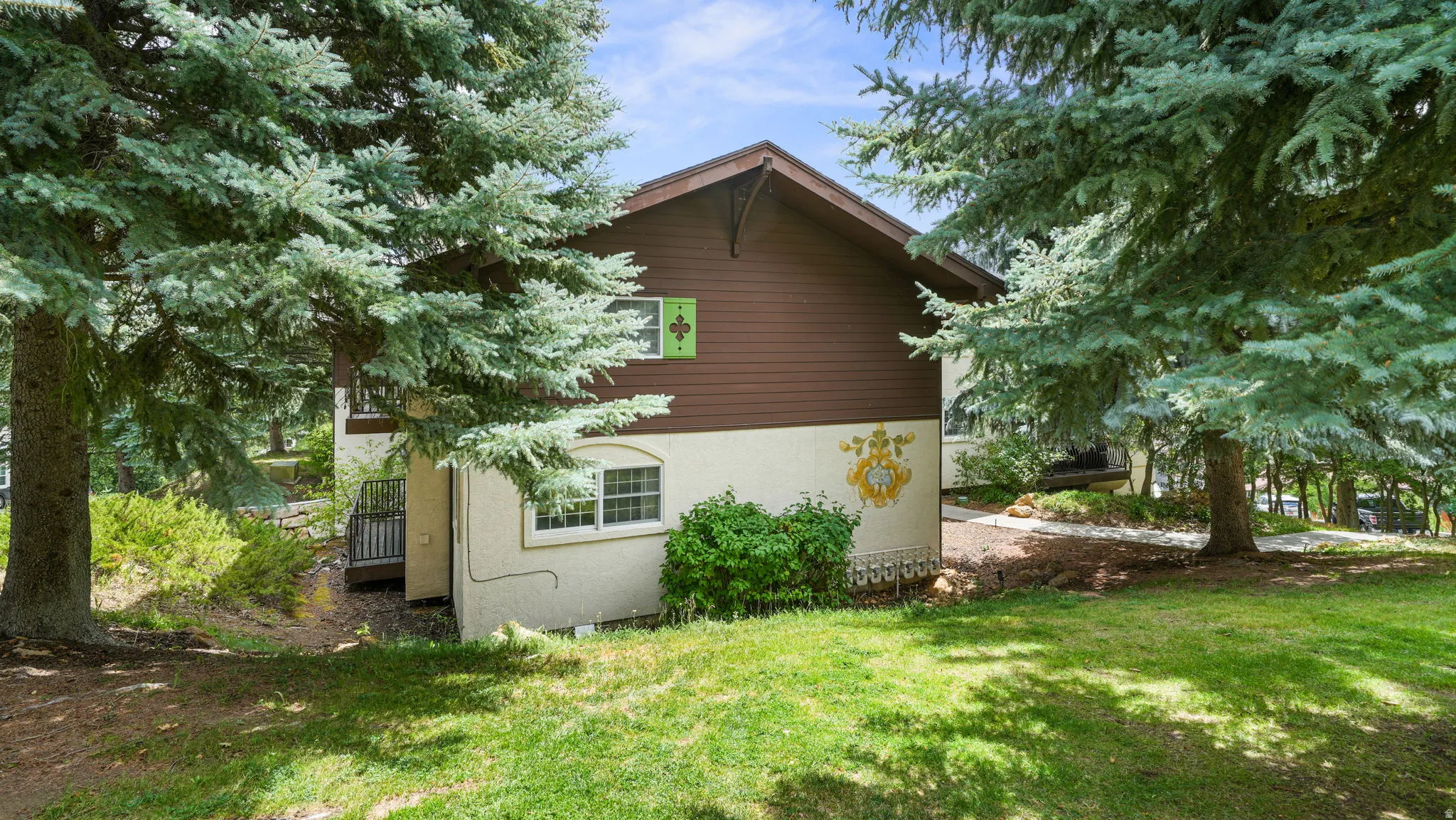 View of property exterior with a yard and stucco siding