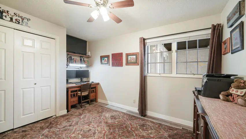 Office space with a textured ceiling and ceiling fan