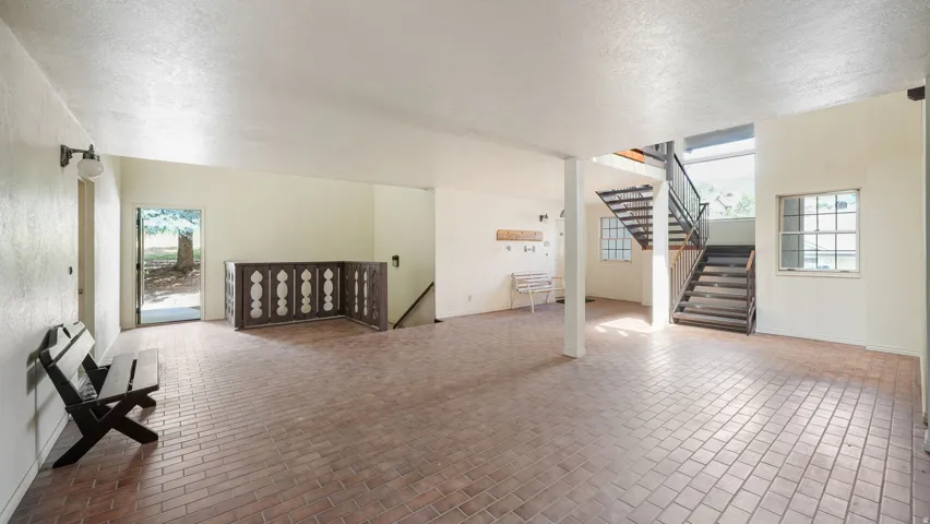 Additional living space with a textured ceiling and brick patterned floors