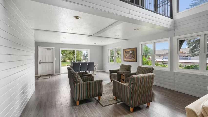 Living area with wooden walls and hardwood / wood-style flooring