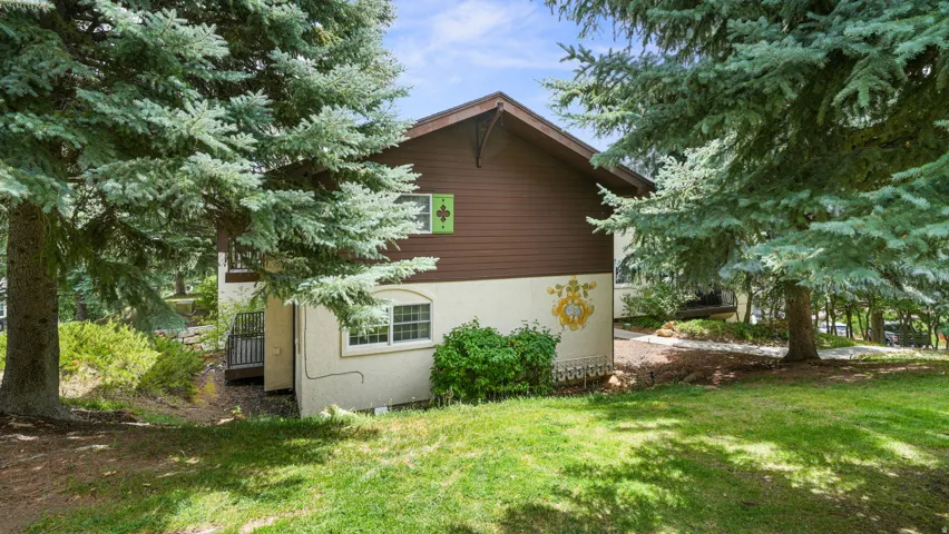 View of property exterior with a yard and stucco siding