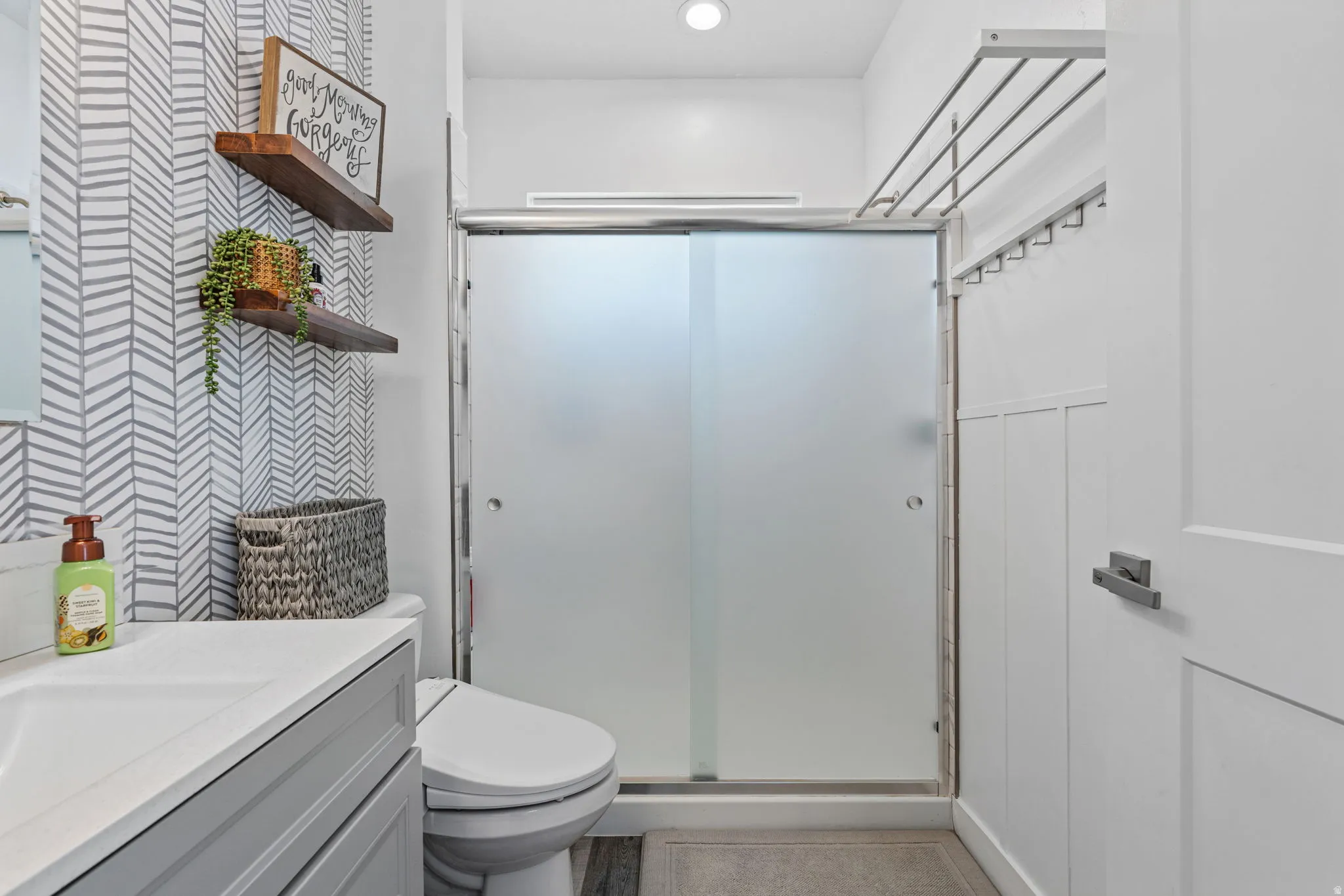 Full bathroom featuring a stall shower, vanity, wallpapered walls, and recessed lighting