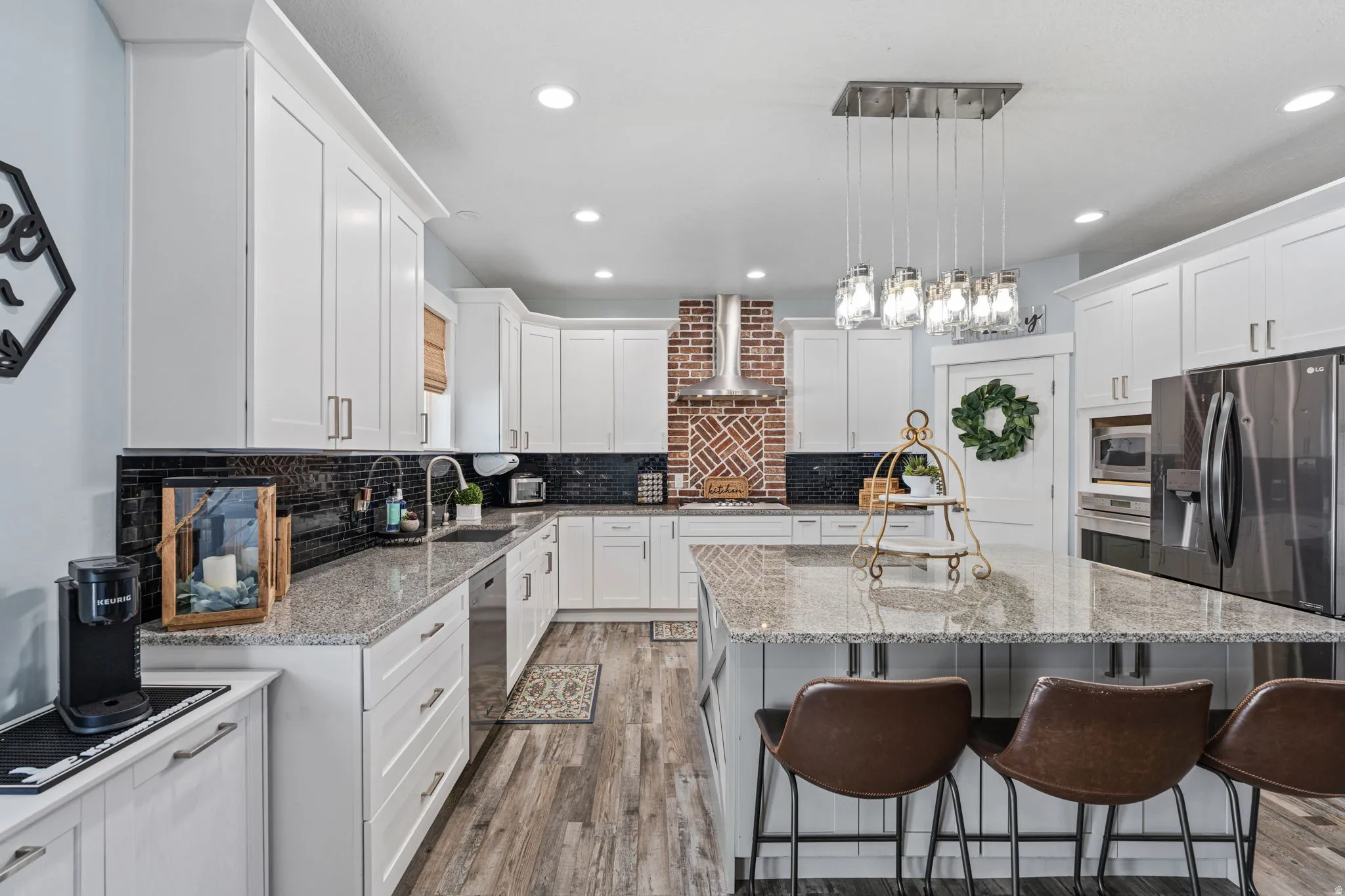 Kitchen with light stone countertops, white cabinets, and light wood-type flooring