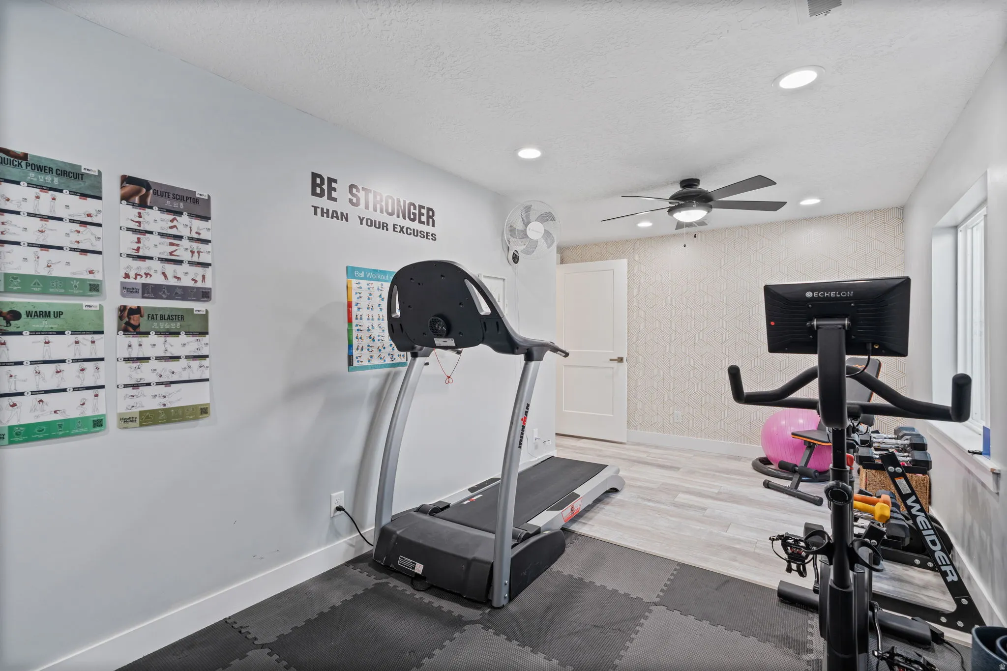 Exercise room with wallpapered walls, a ceiling fan, recessed lighting, and a textured ceiling