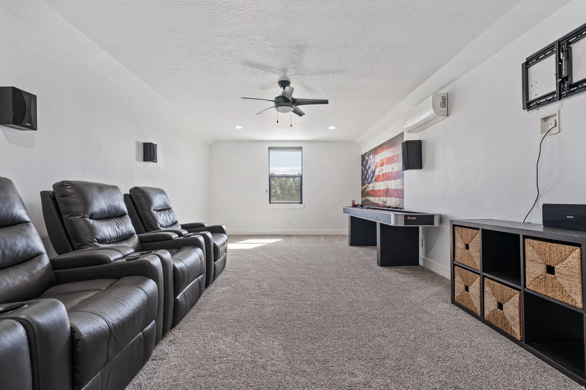Home theater featuring carpet flooring, a textured ceiling, and ceiling fan
