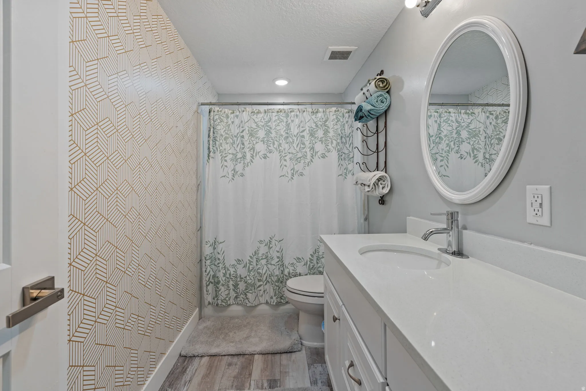 Bathroom featuring vanity, light wood-type flooring, and a textured ceiling