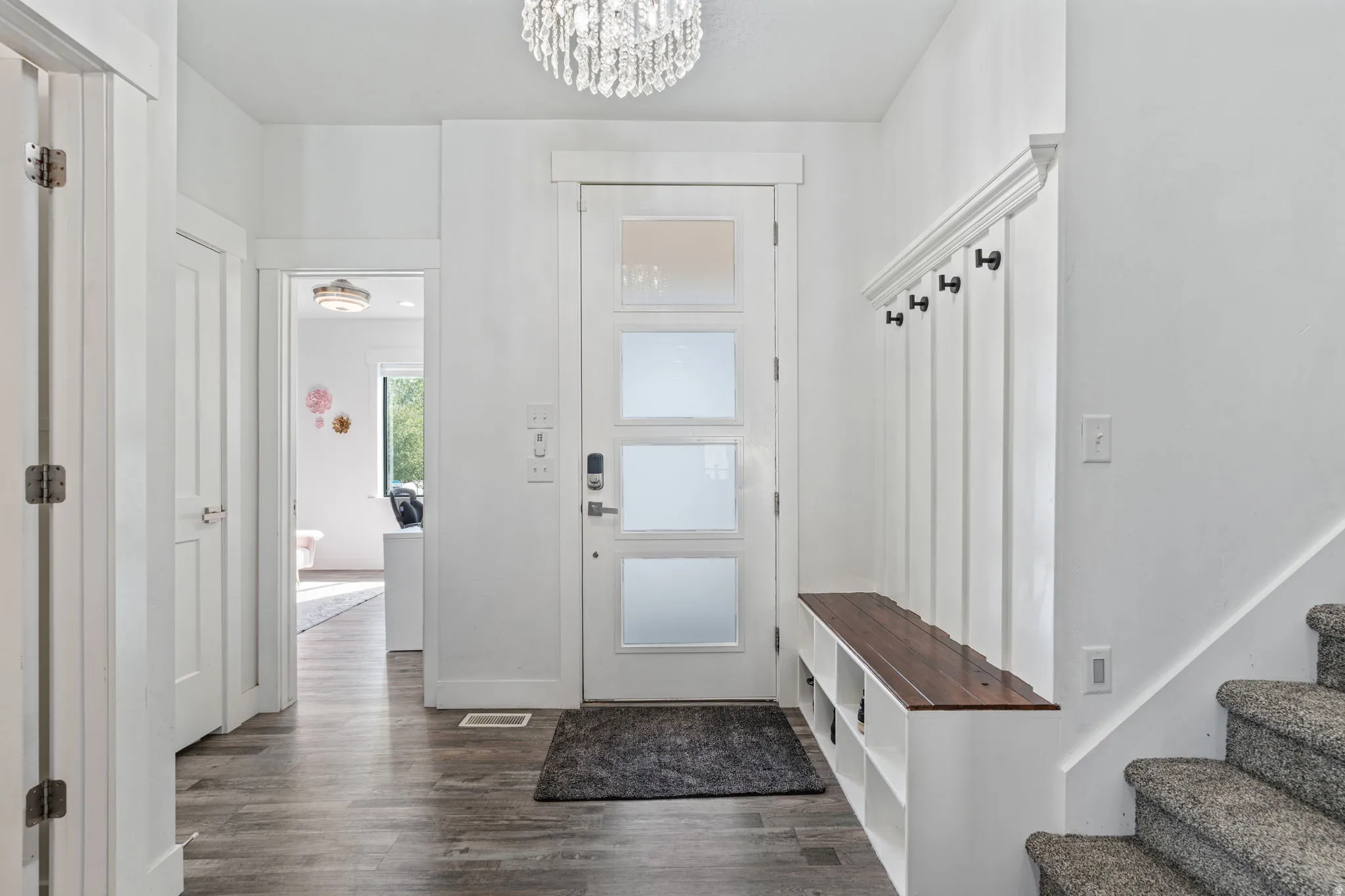 Mudroom featuring dark wood-style floors and a chandelier