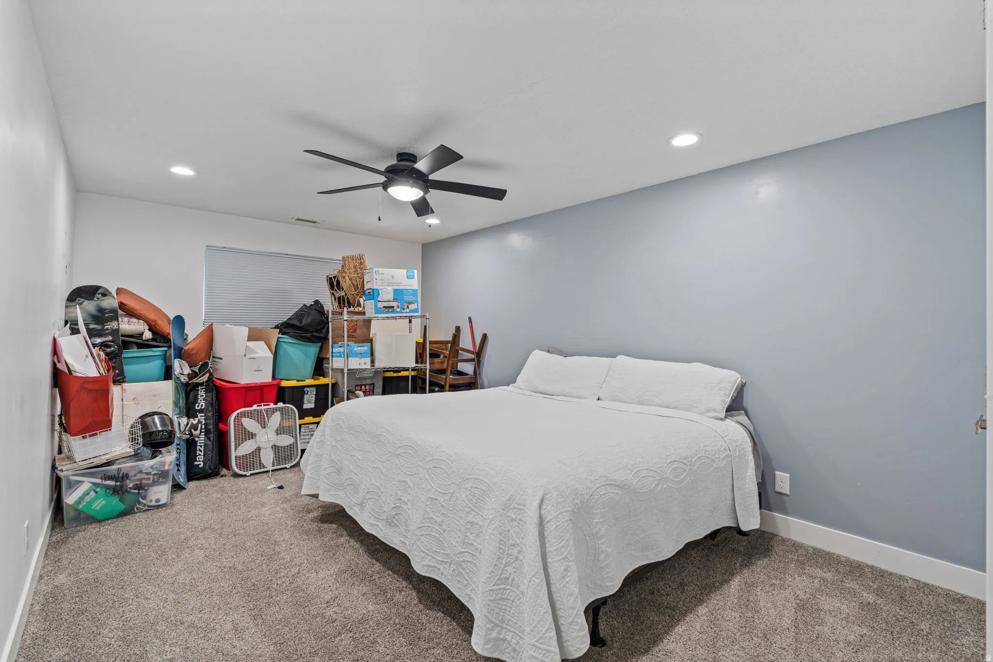 Carpeted bedroom with a ceiling fan and recessed lighting