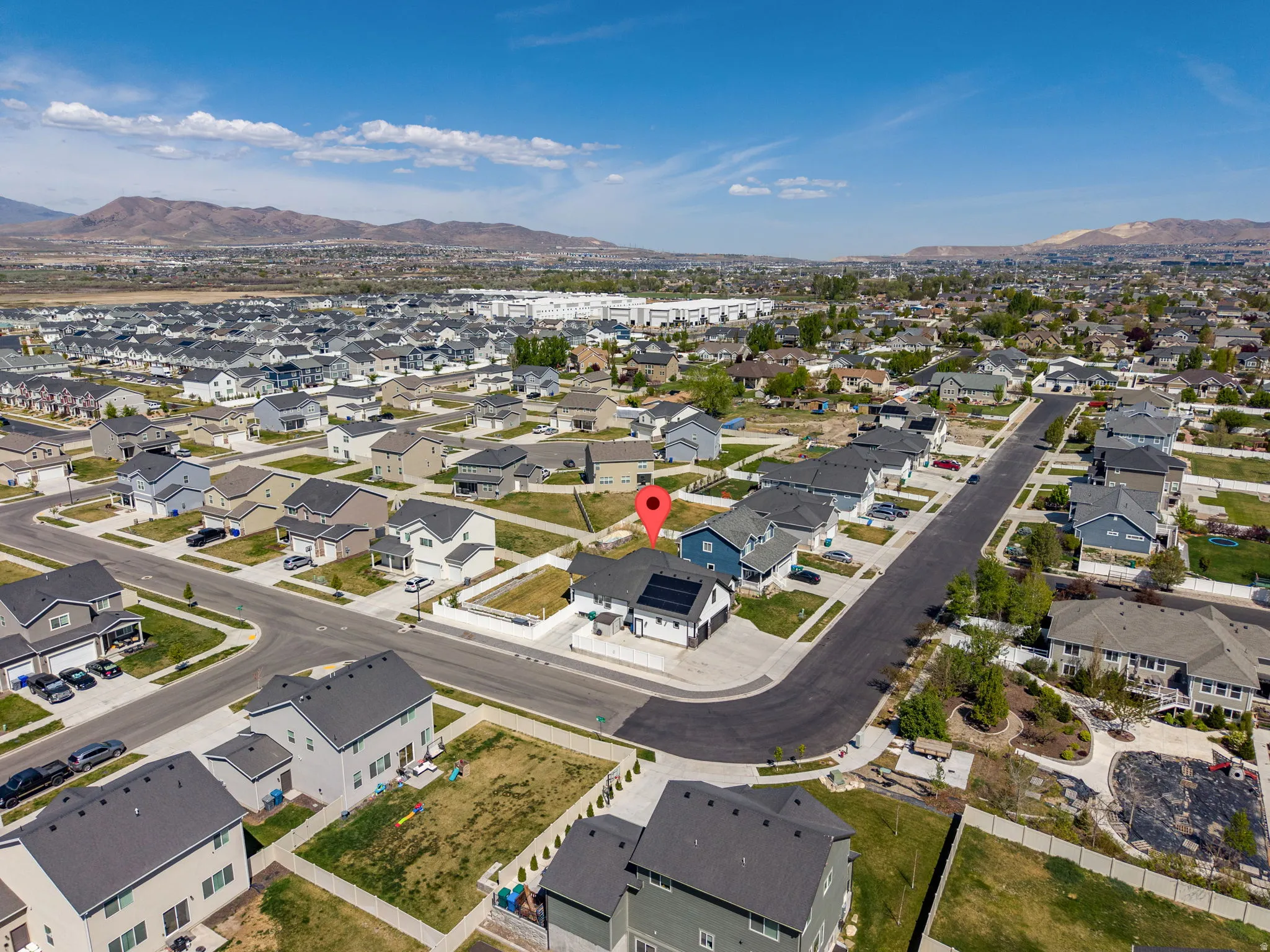Aerial view of property and surrounding area featuring a mountainous background and nearby suburban area
