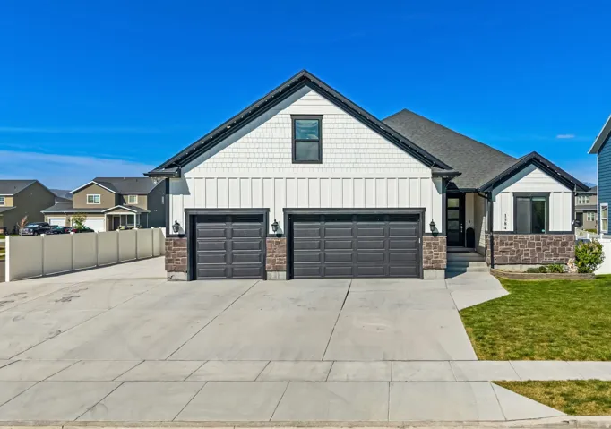 View of front facade featuring board and batten siding and concrete driveway