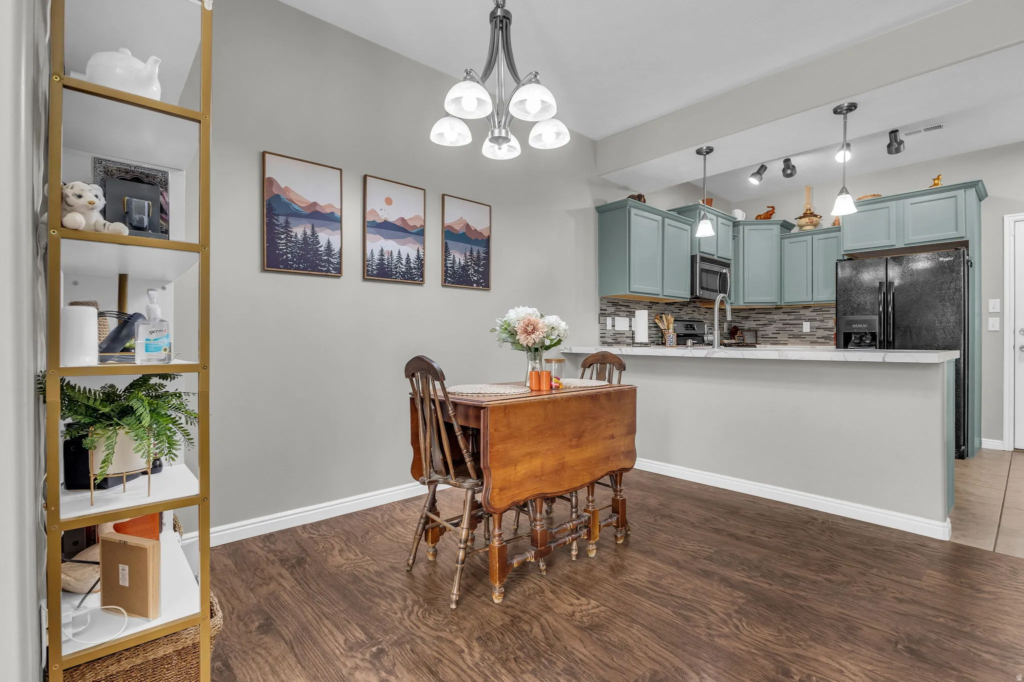 Dining area with dark wood-type flooring and suspended lighting