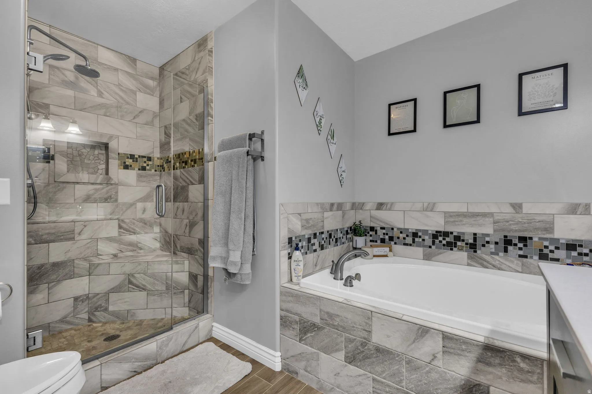 Bathroom featuring a stall shower, a garden tub, and wood tiled floors