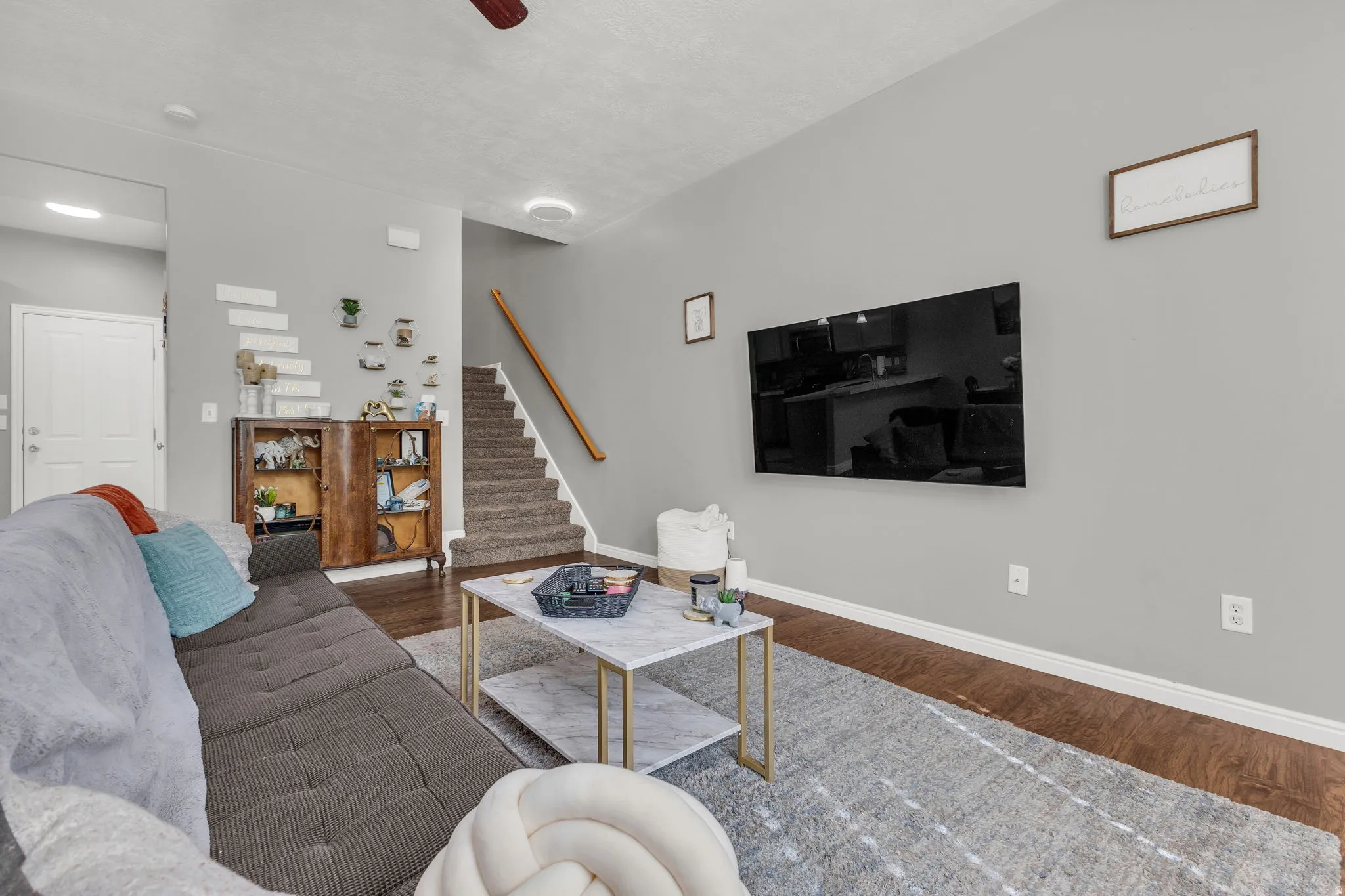 Living area featuring dark wood-style floors and a ceiling fan