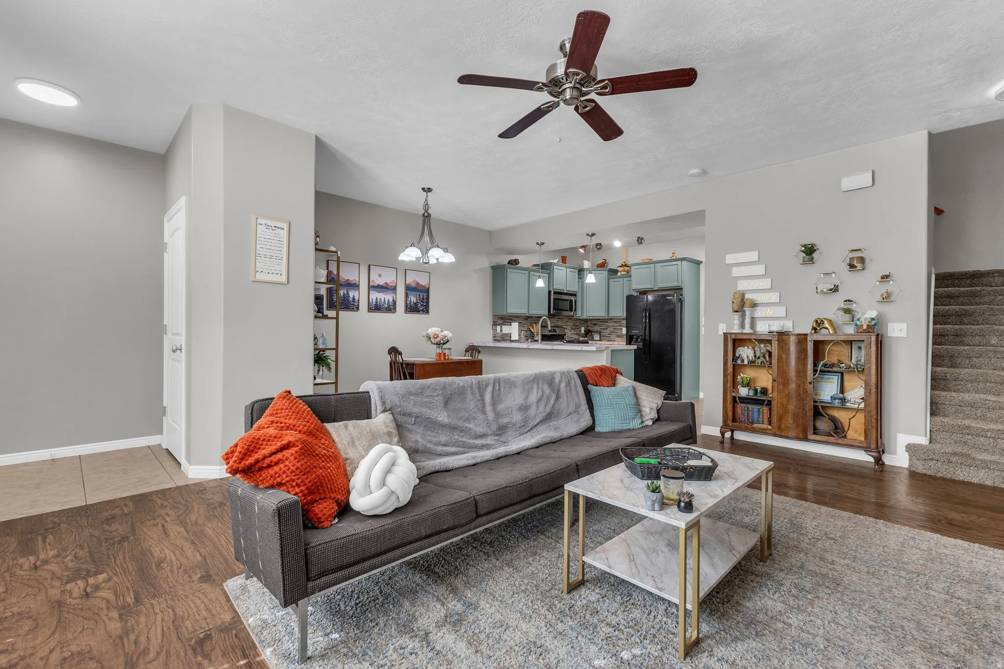 Living area featuring dark wood-style flooring, a ceiling fan, and suspended lighting