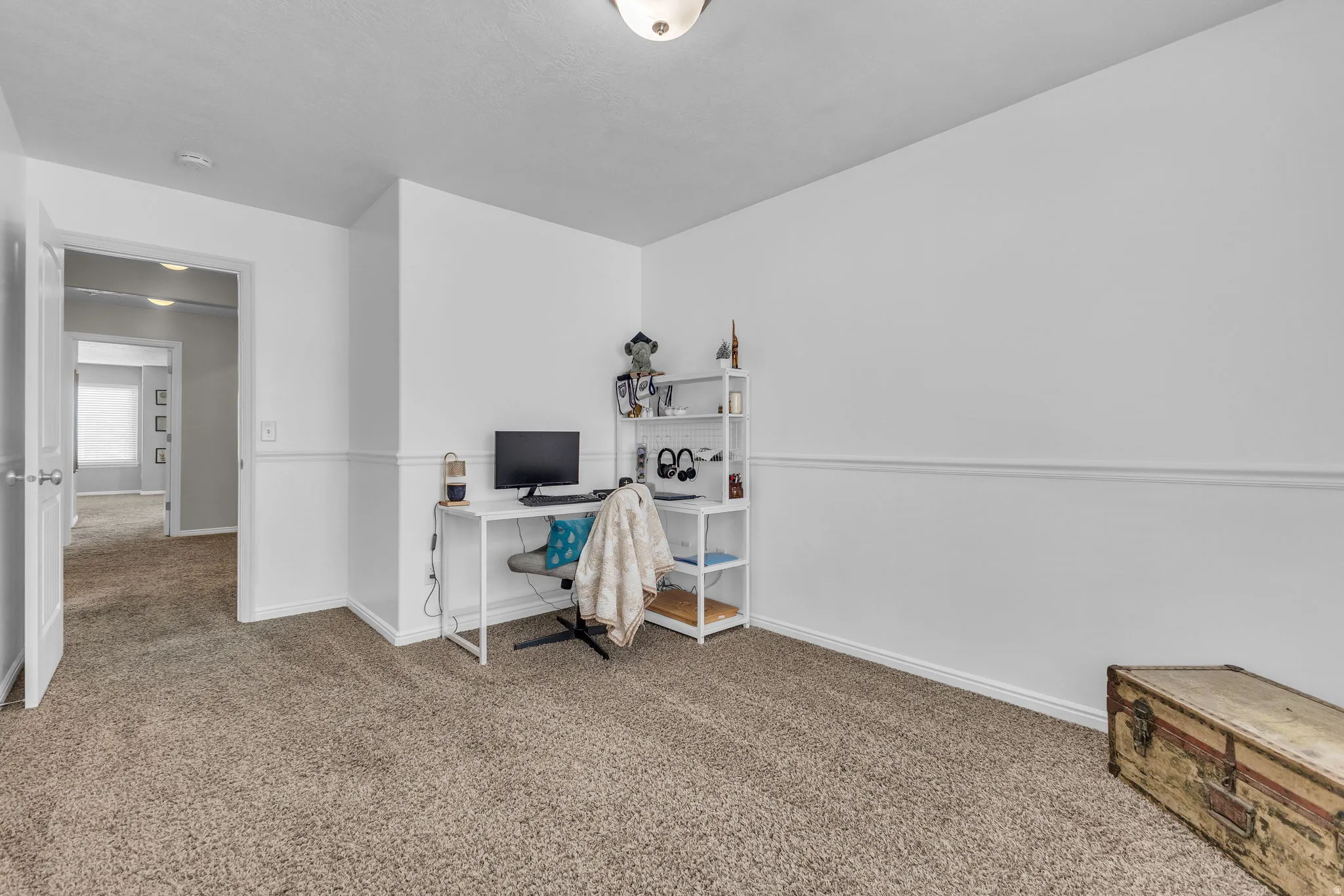 Office with light colored carpet and baseboards
