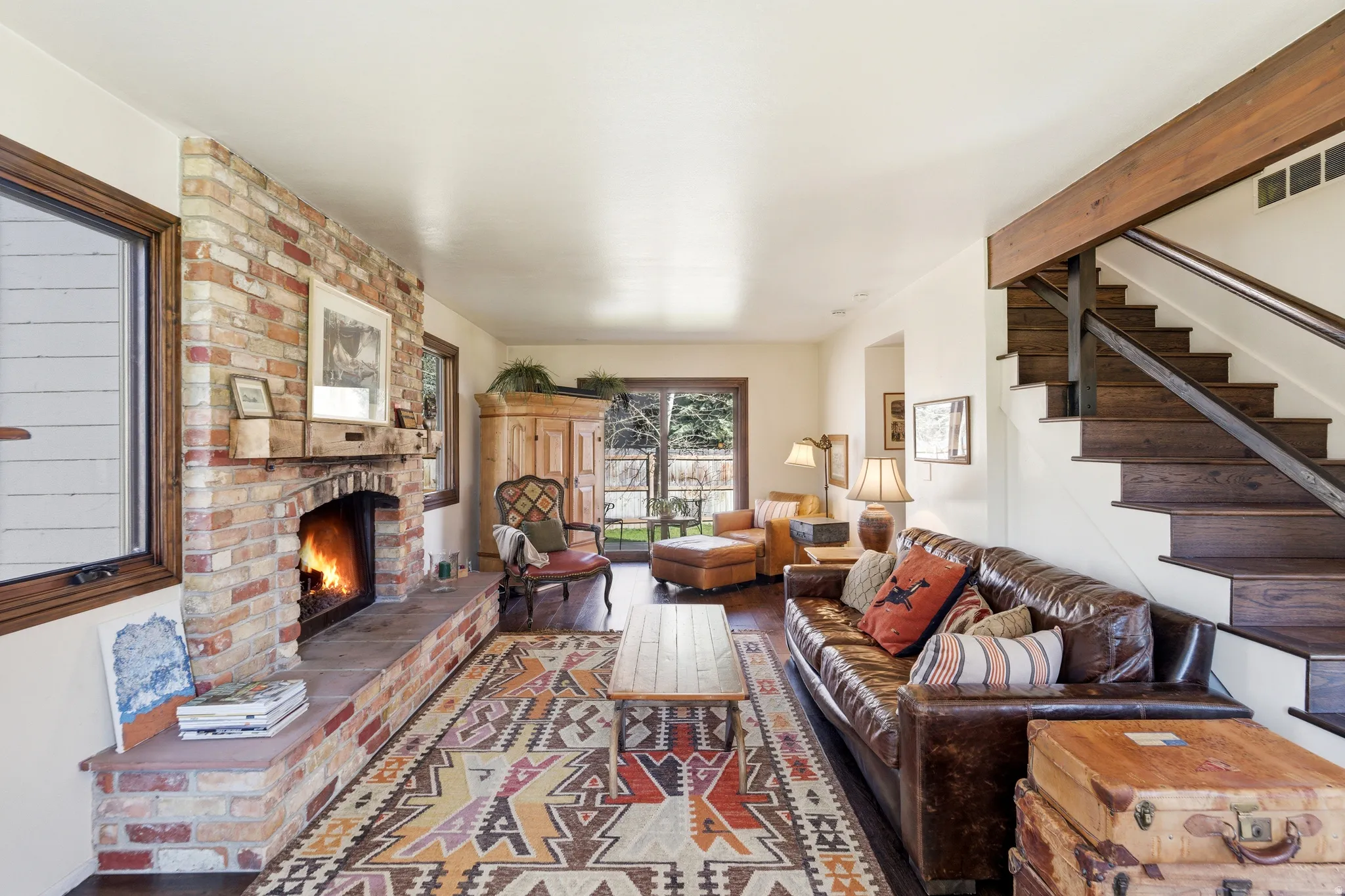 Living room with a brick fireplace and wood finished floors