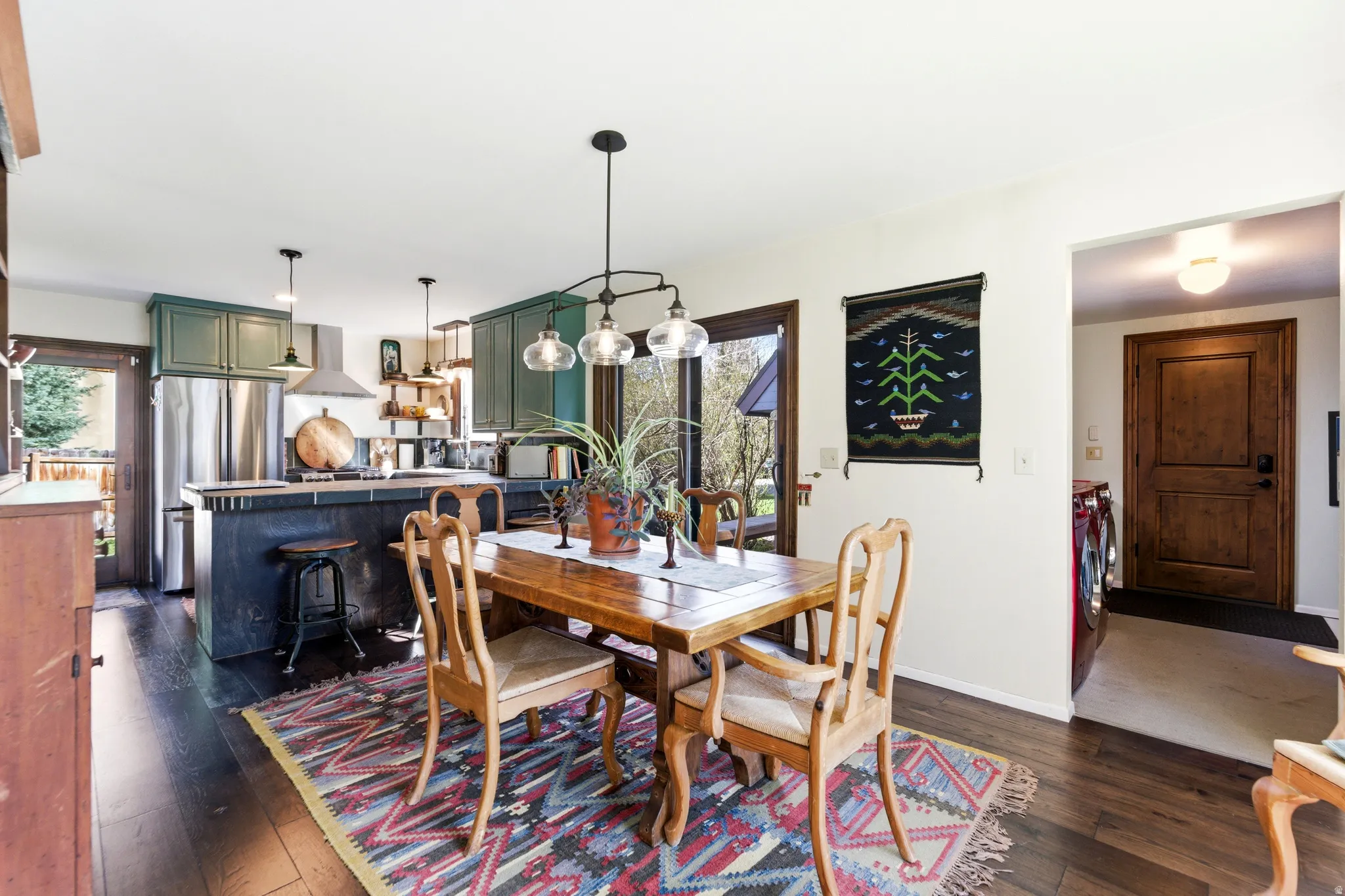Dining area featuring dark wood finished floors, plenty of natural light, and washing machine and clothes dryer