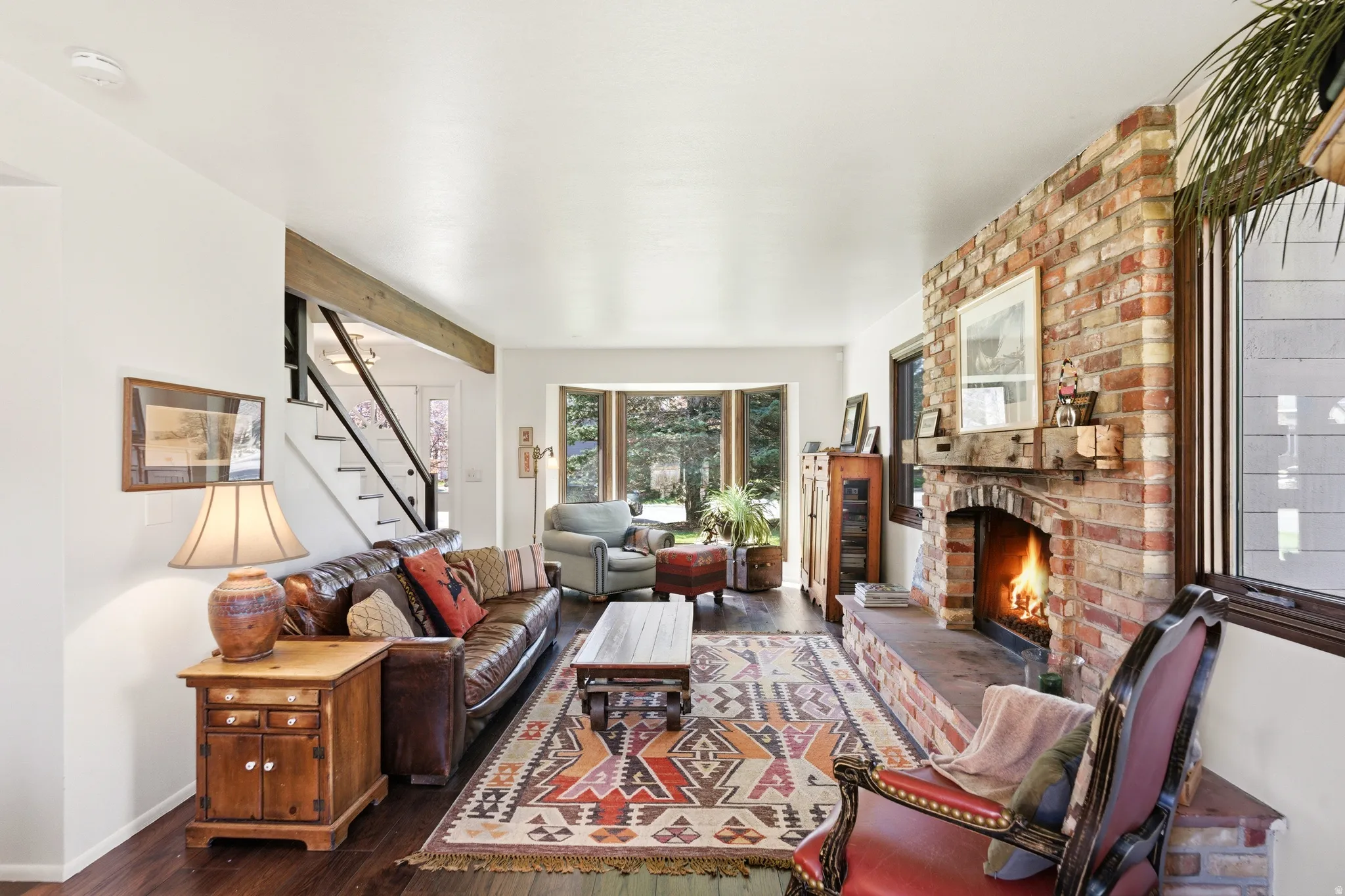 Living room featuring dark wood-style flooring and a brick fireplace