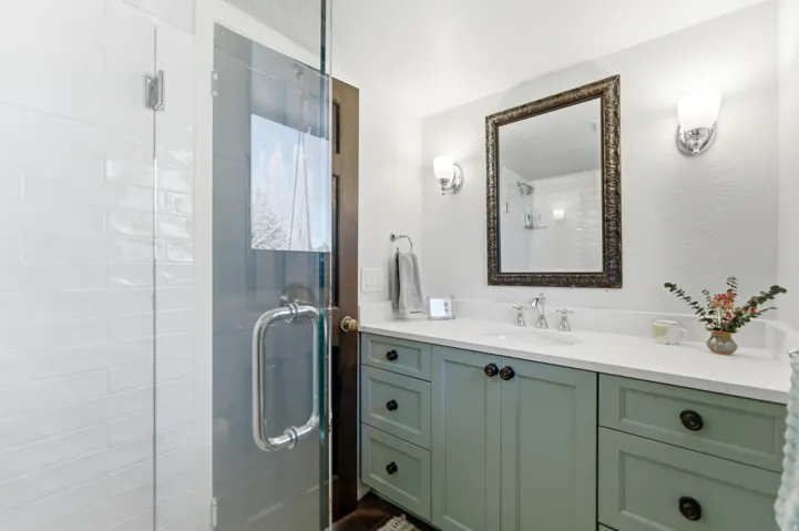 Full bath featuring vanity, a stall shower, and a textured wall