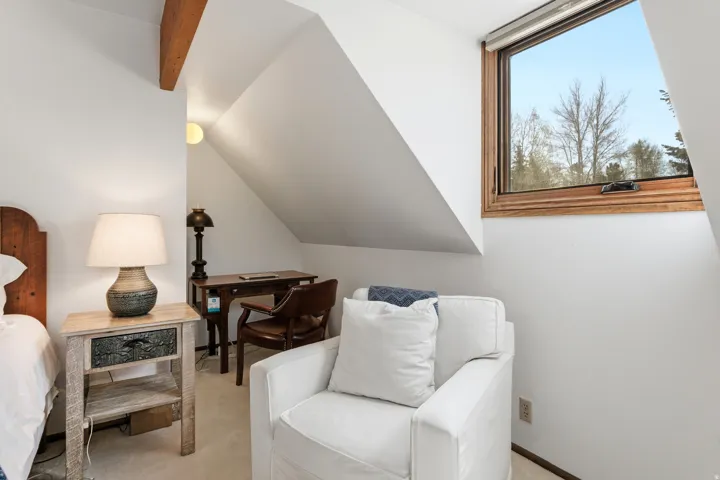 Sitting room featuring carpet flooring and vaulted ceiling with beams
