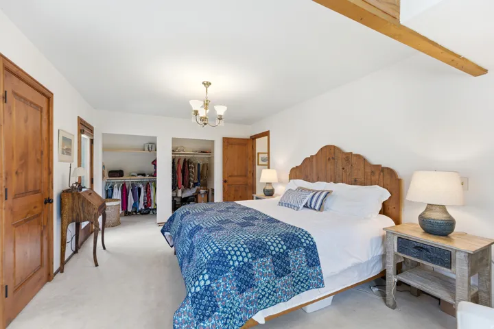 Bedroom with carpet floors, a chandelier, and a closet