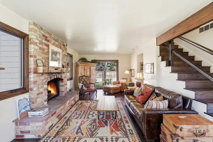 Living room with a brick fireplace and wood finished floors