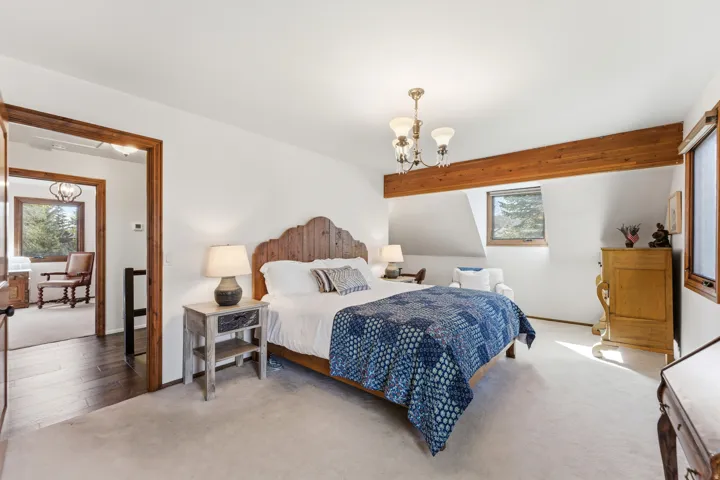 Carpeted bedroom featuring a chandelier and baseboards