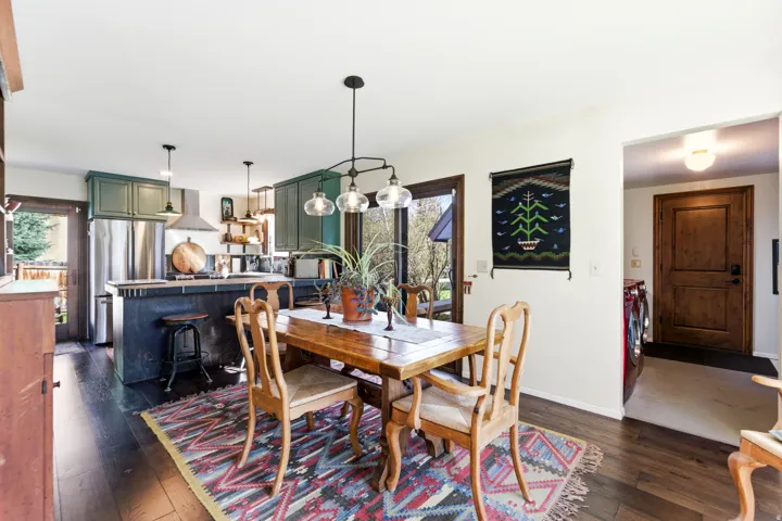 Dining area featuring dark wood finished floors, plenty of natural light, and washing machine and clothes dryer