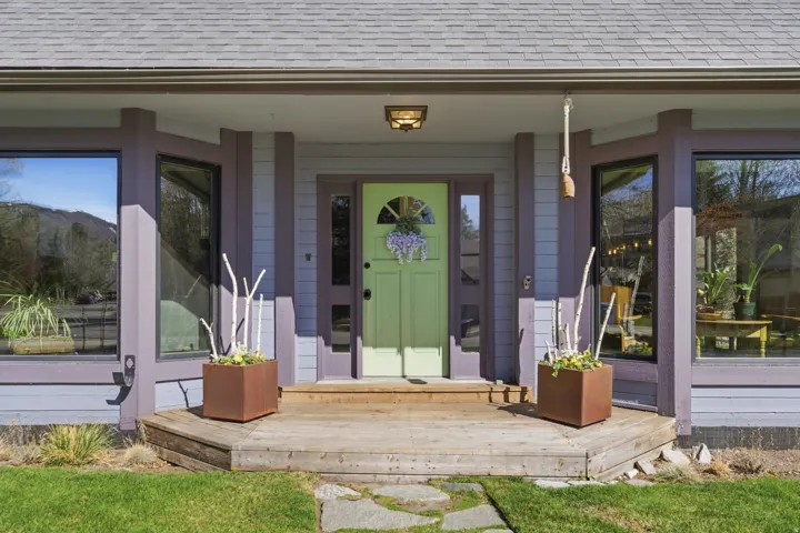 Entrance to property with roof with shingles, a porch, and a mountain view