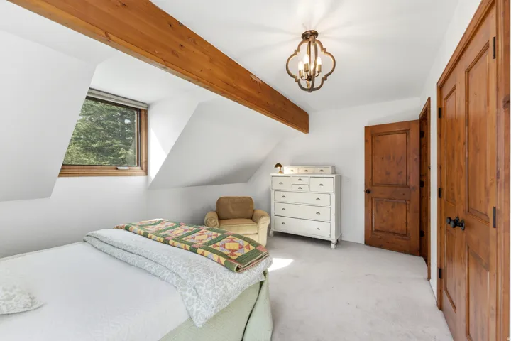 Bedroom with carpet, suspended lighting, a closet, and beam ceiling