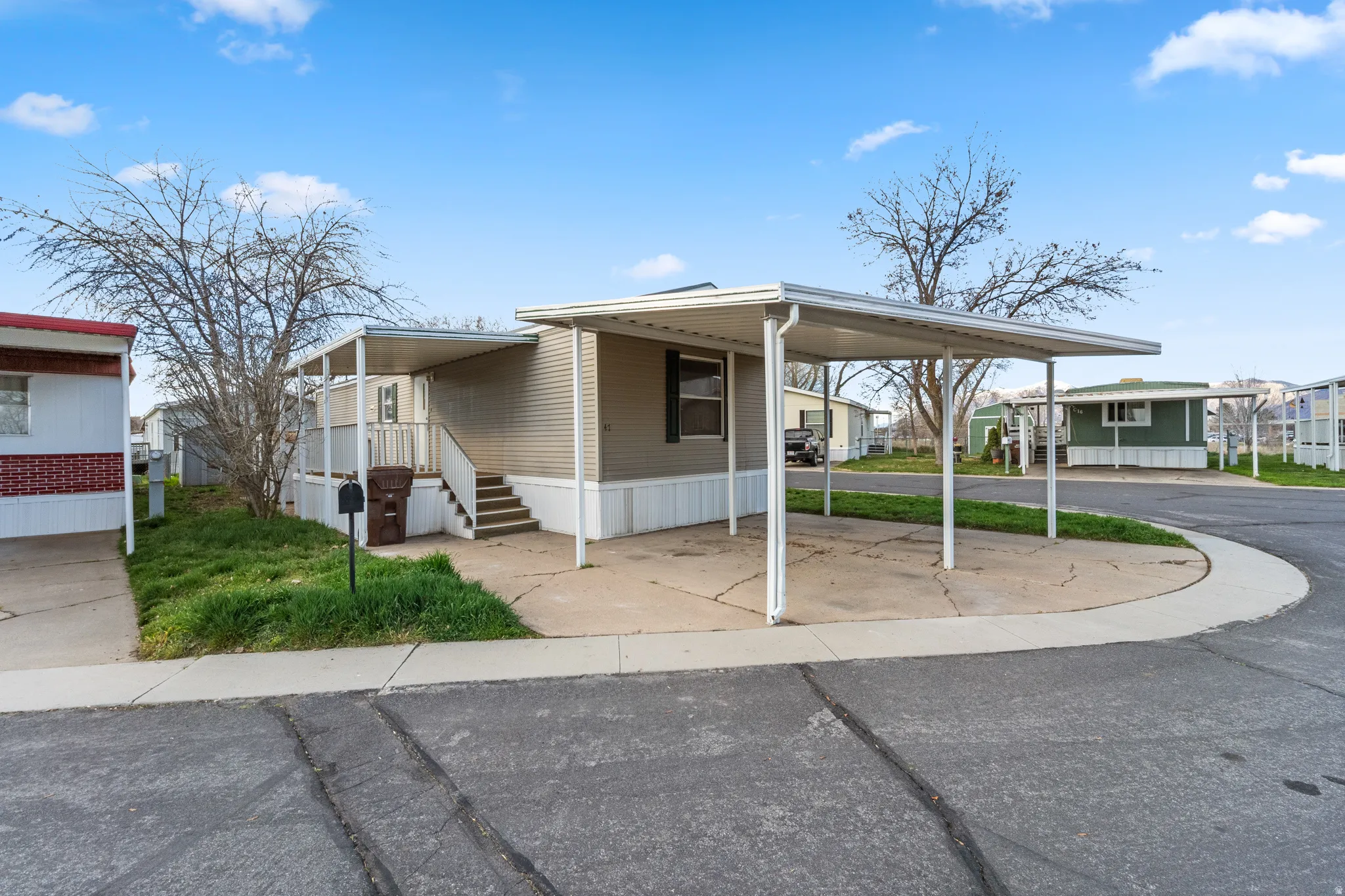 Manufactured / mobile home featuring a residential view, a carport, and driveway