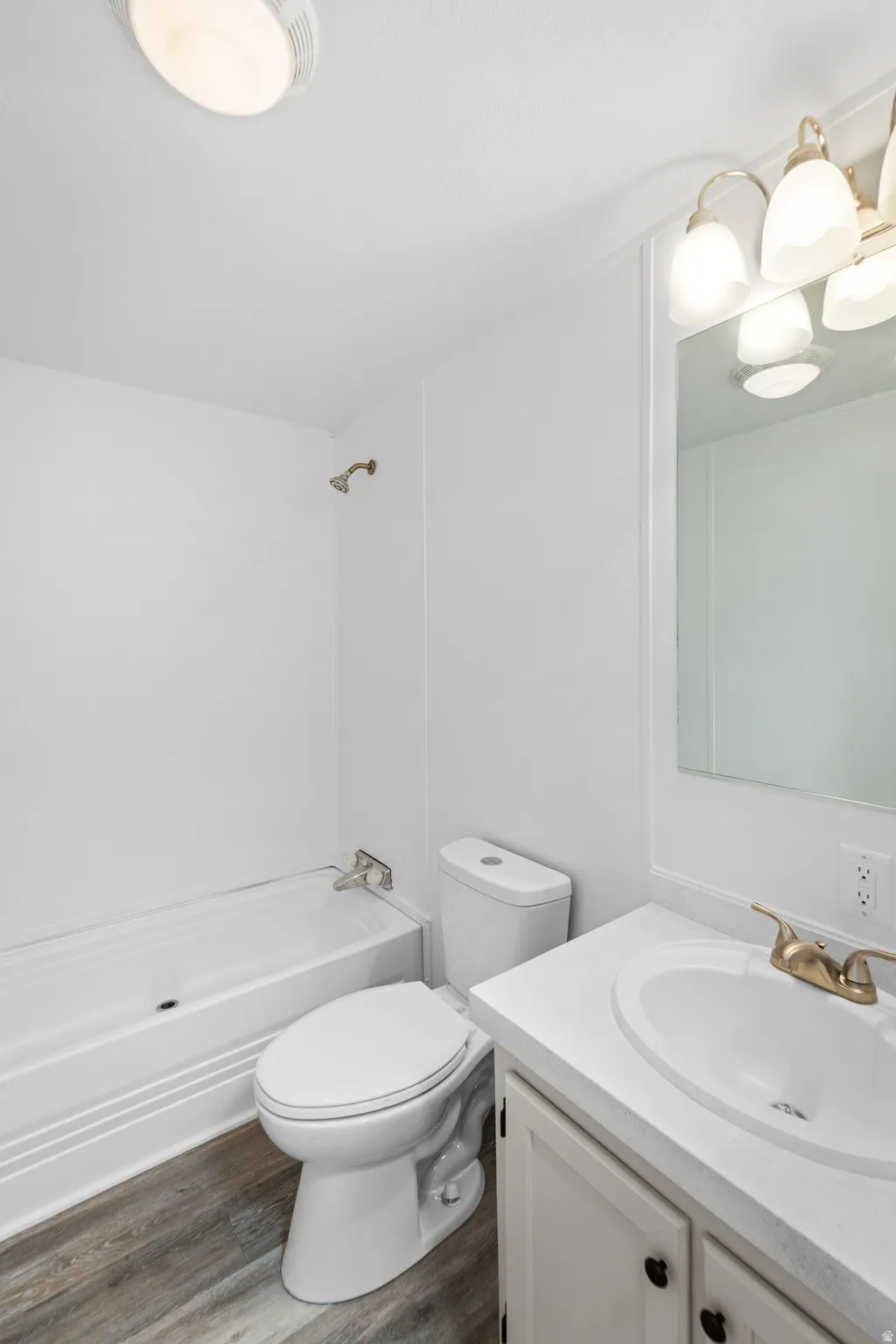 Bathroom with vanity, dark wood finished floors, and tub / shower combination