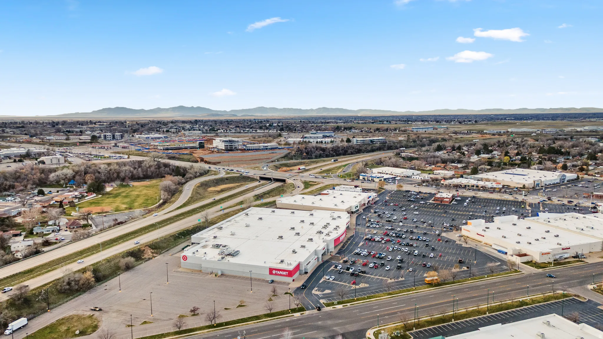 Aerial view of property's location with a mountainous background and a commercial area