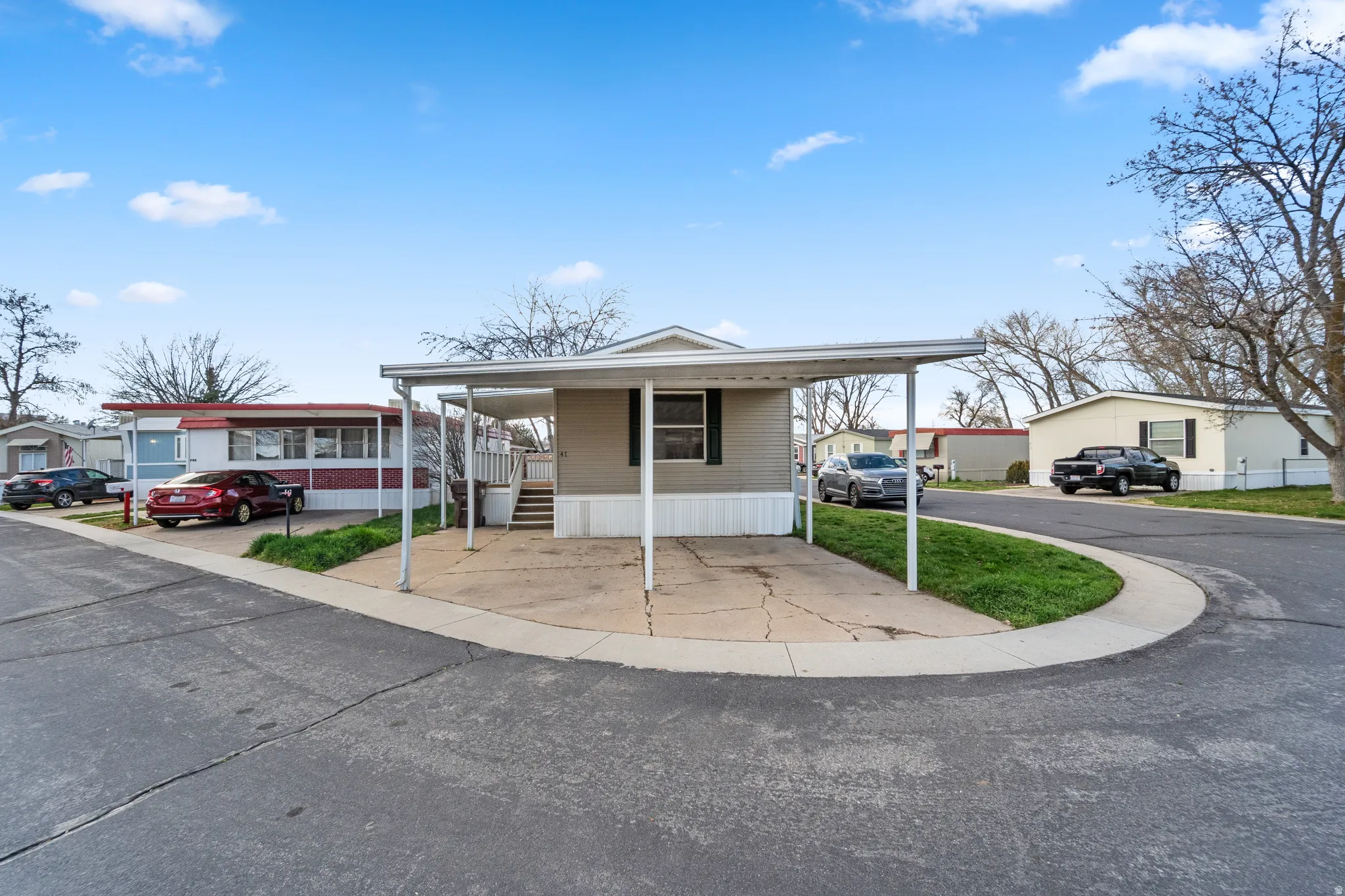 Manufactured / mobile home with a residential view, a carport, and a porch