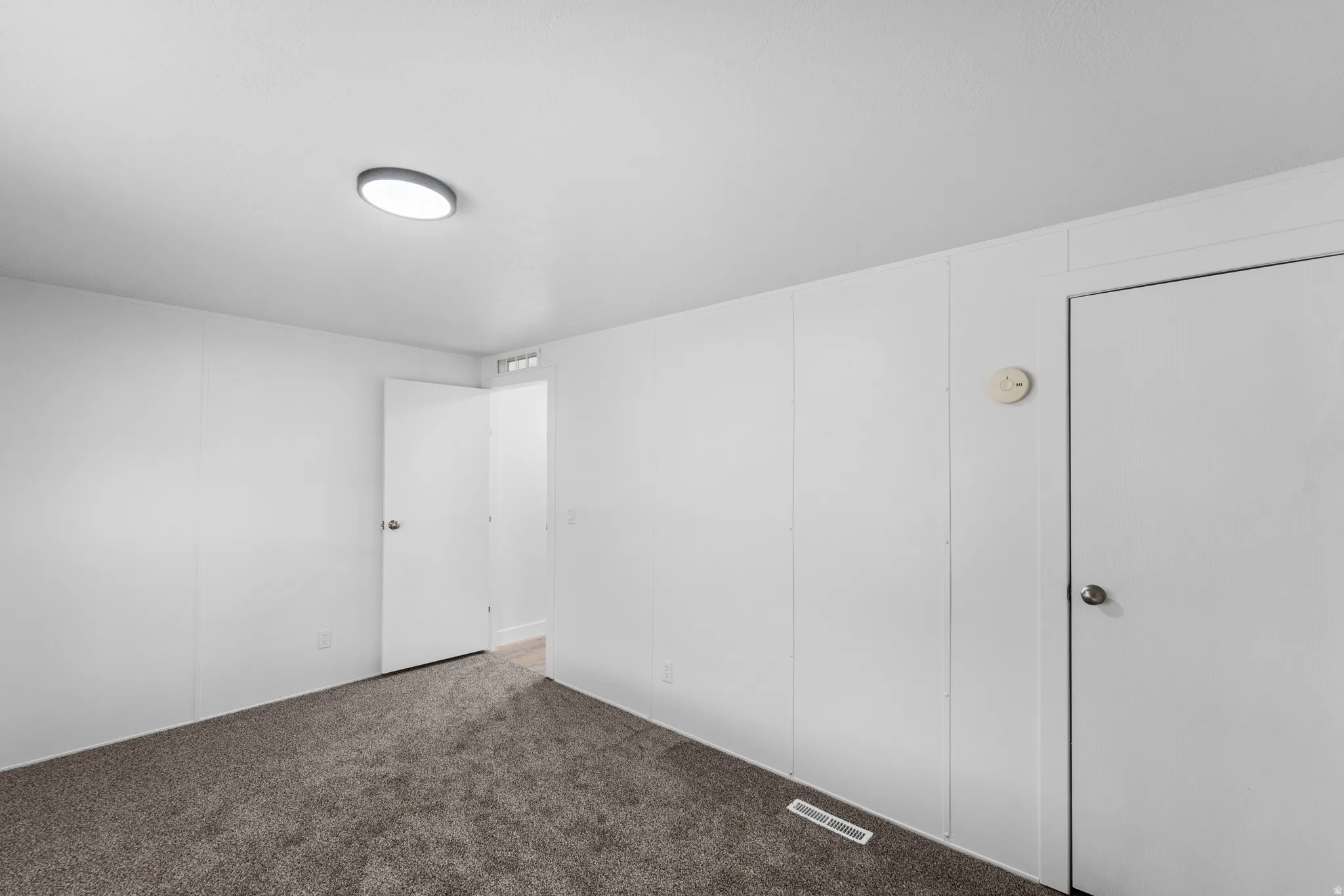 Unfurnished bedroom with light carpet