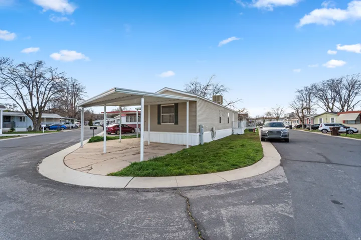 View of front of property with a residential view, a carport, and a front yard