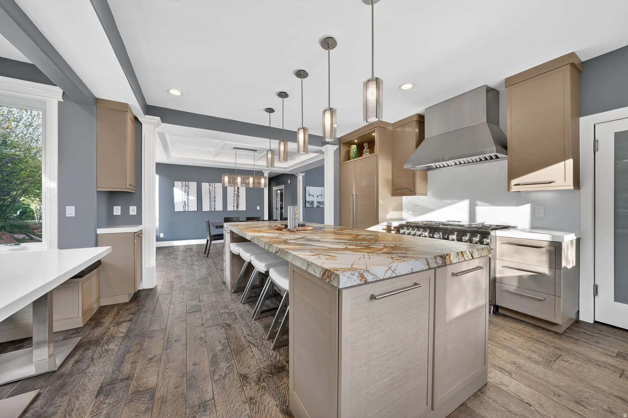 Kitchen featuring light wood finish cabinetry, a kitchen bar, dark wood-type flooring, and a spacious island