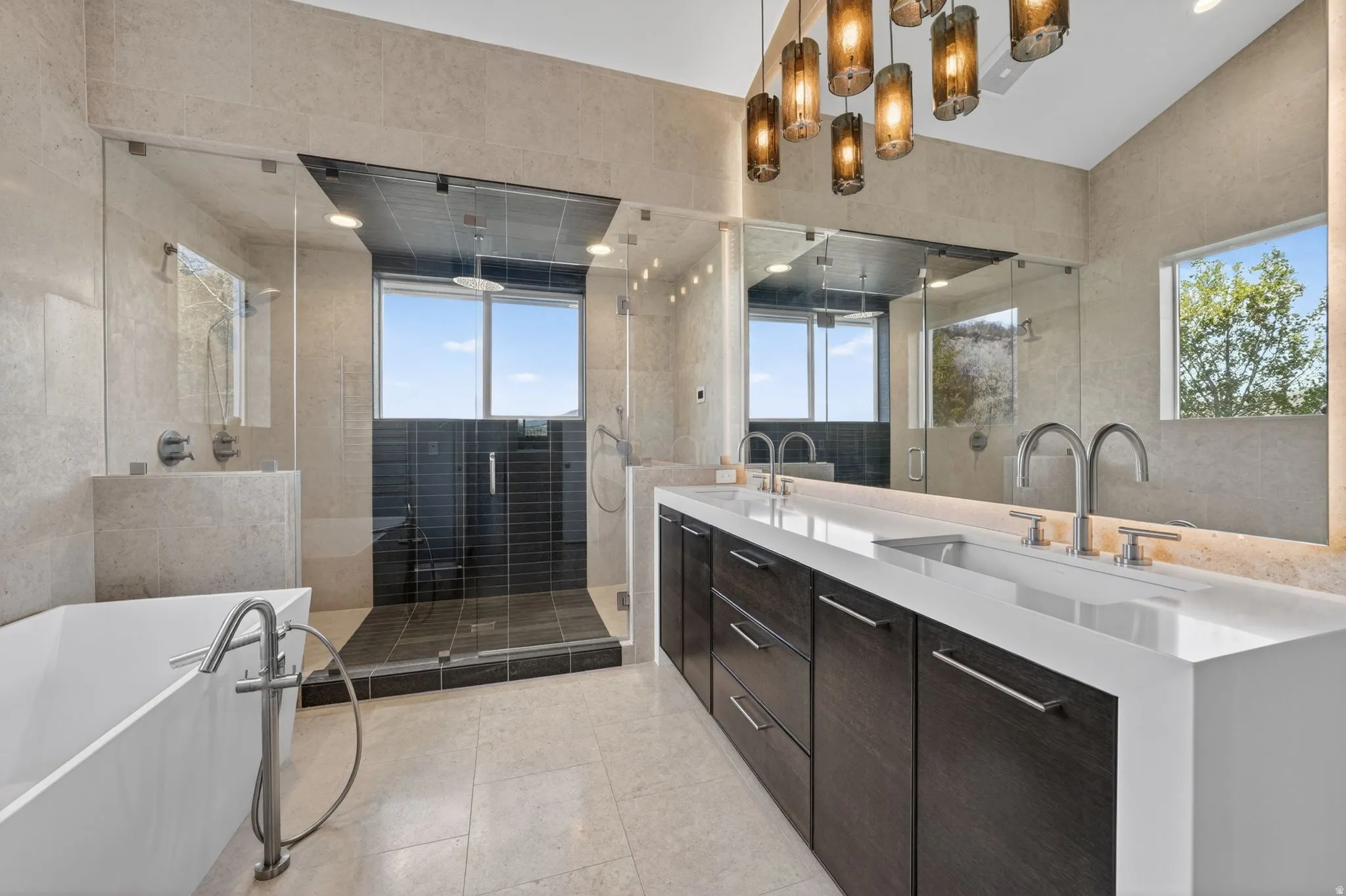 Full bath featuring a freestanding tub, double vanity, plenty of natural light, tile walls, and a shower stall