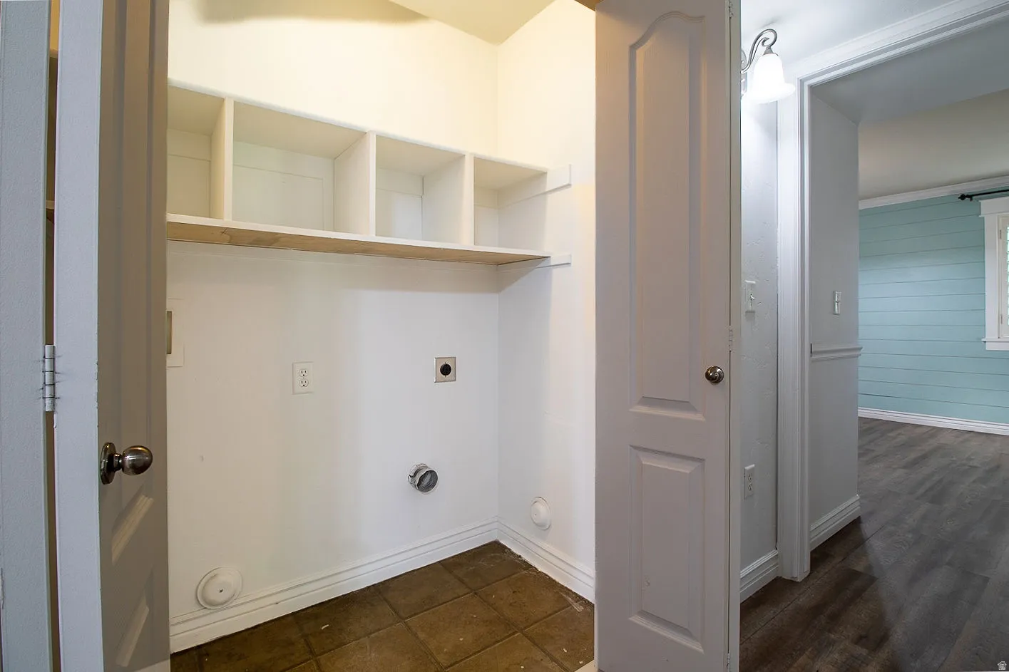 Laundry area with hookup for an electric dryer and dark wood-style flooring