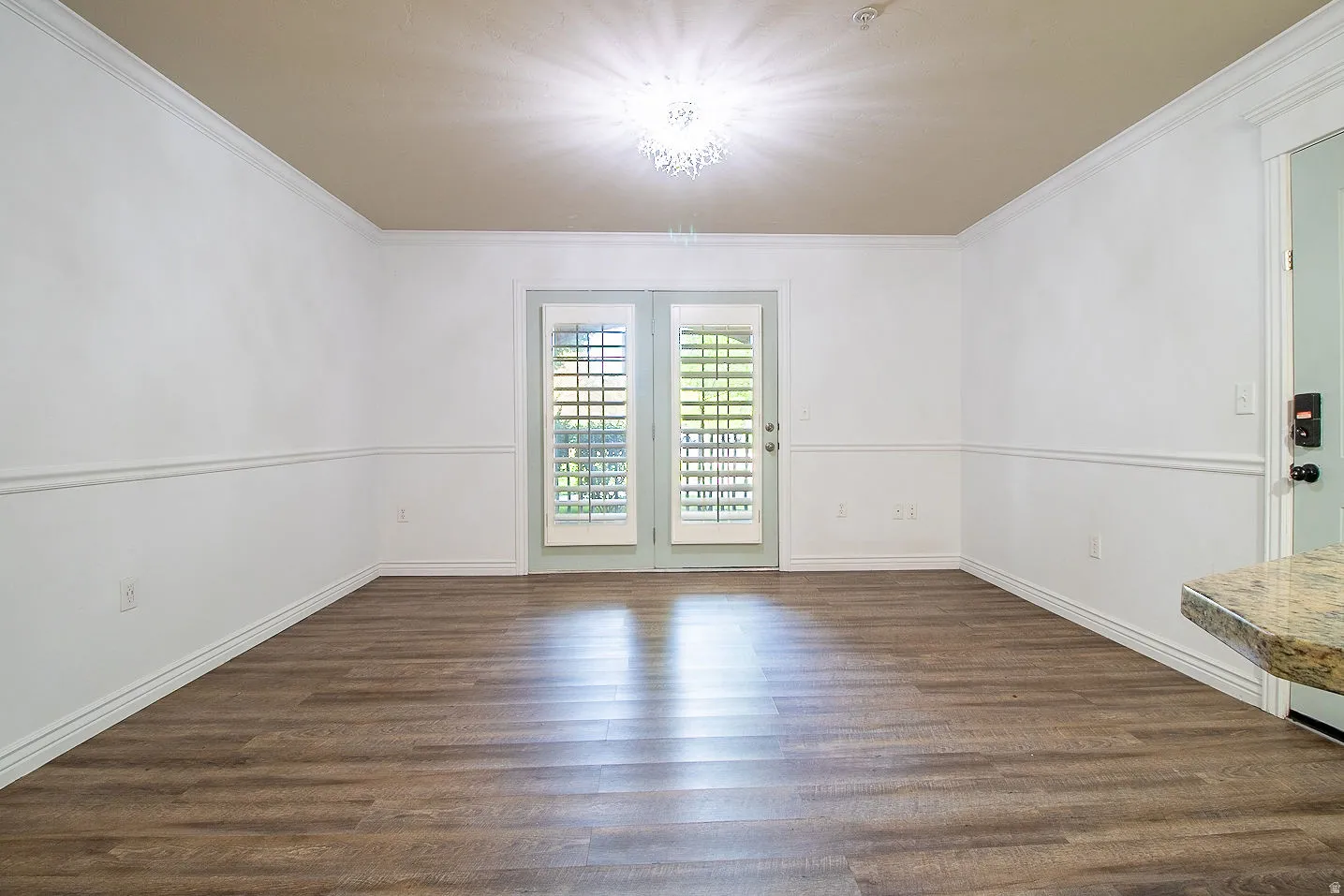 Empty room with dark wood-type flooring and crown molding